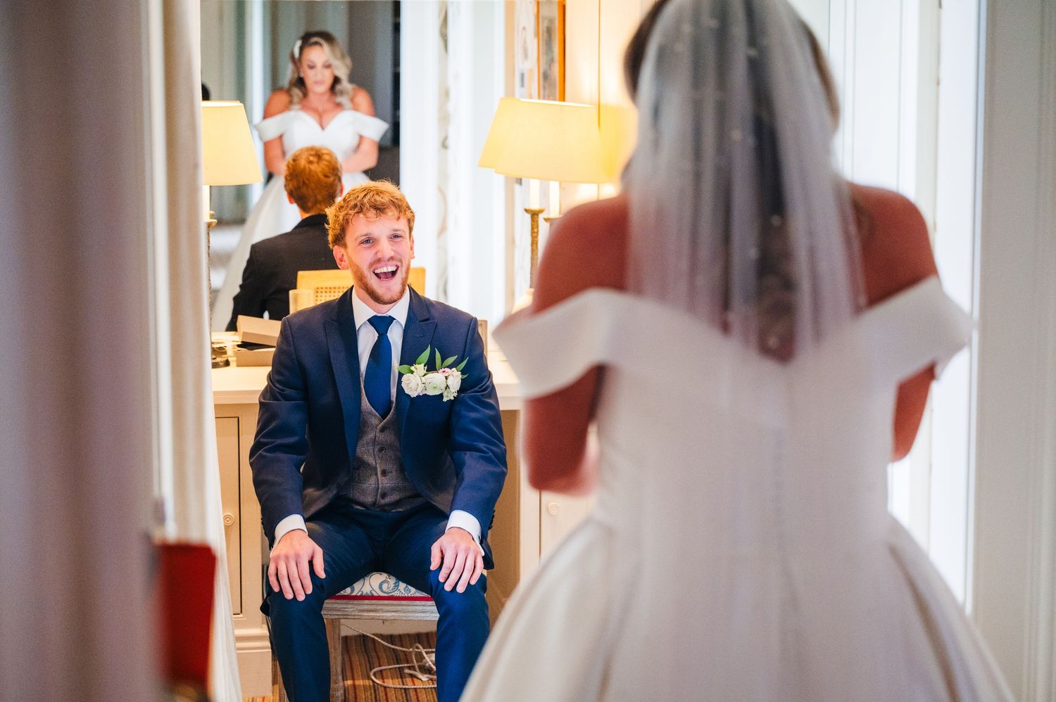 Wedding guests laugh and celebrate during a joyful reception in an elegant room with warm lighting.  Virginia Park Lodge Wedding Photographe