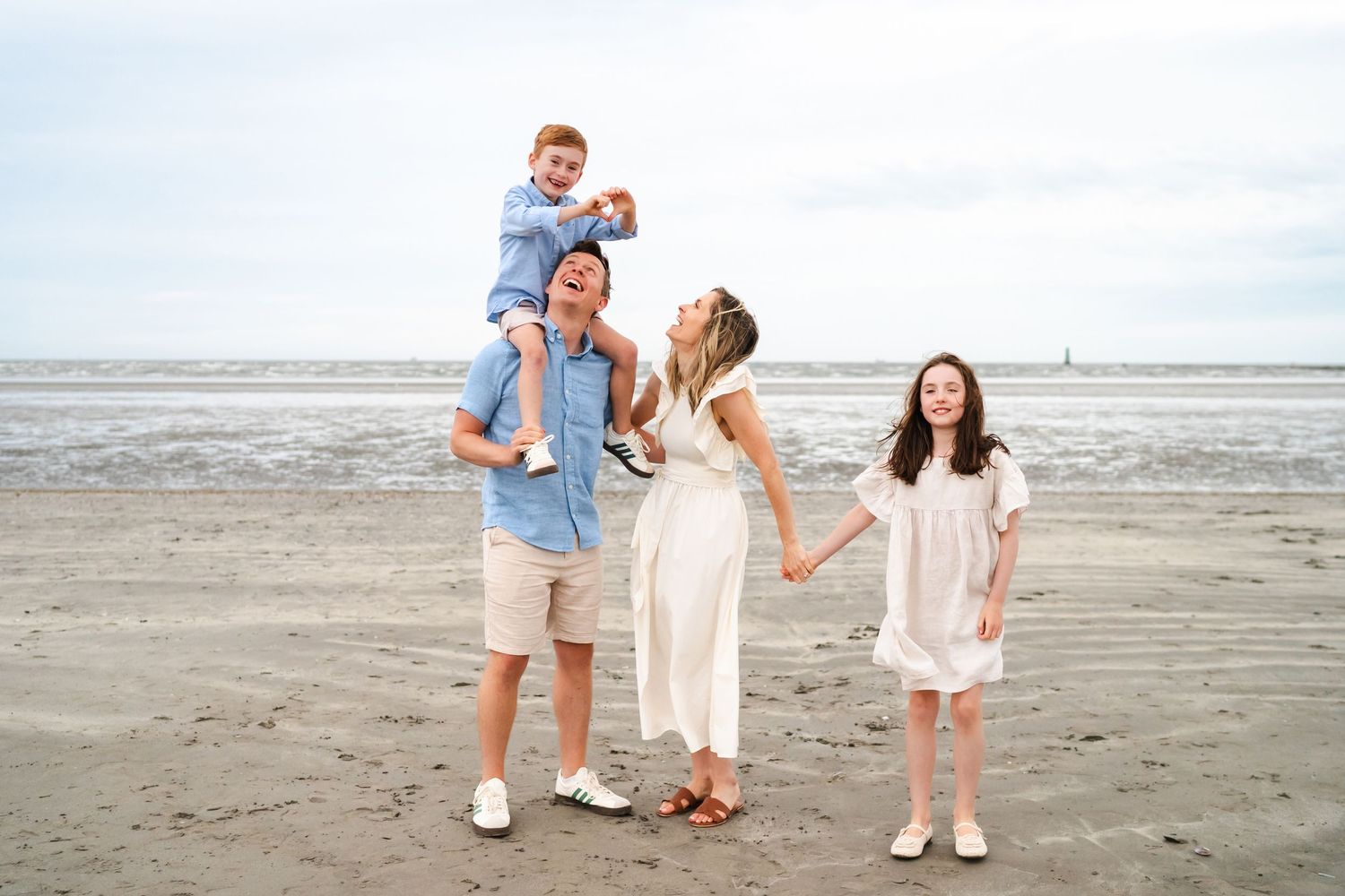 Happy family enjoying time together at the beach on an overcast day.  Family photographer Dublin Ireland