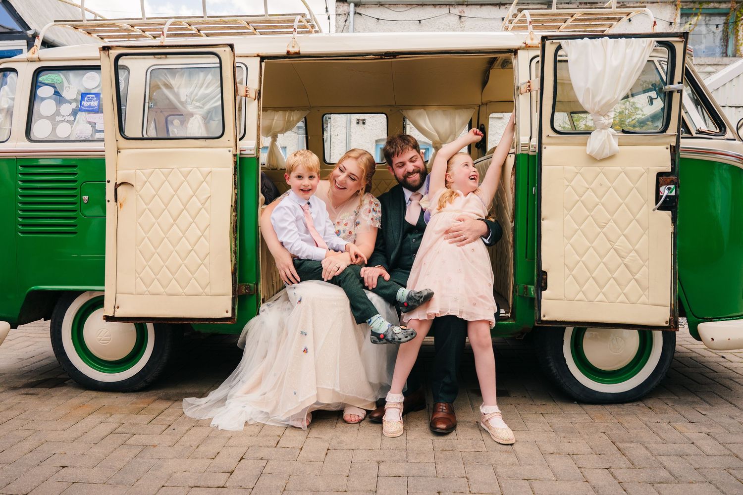 Vintage cream-colored van parked at wedding venue with guests seated nearby. . Village Barn Tyrrellspass wedding photographer Ireland