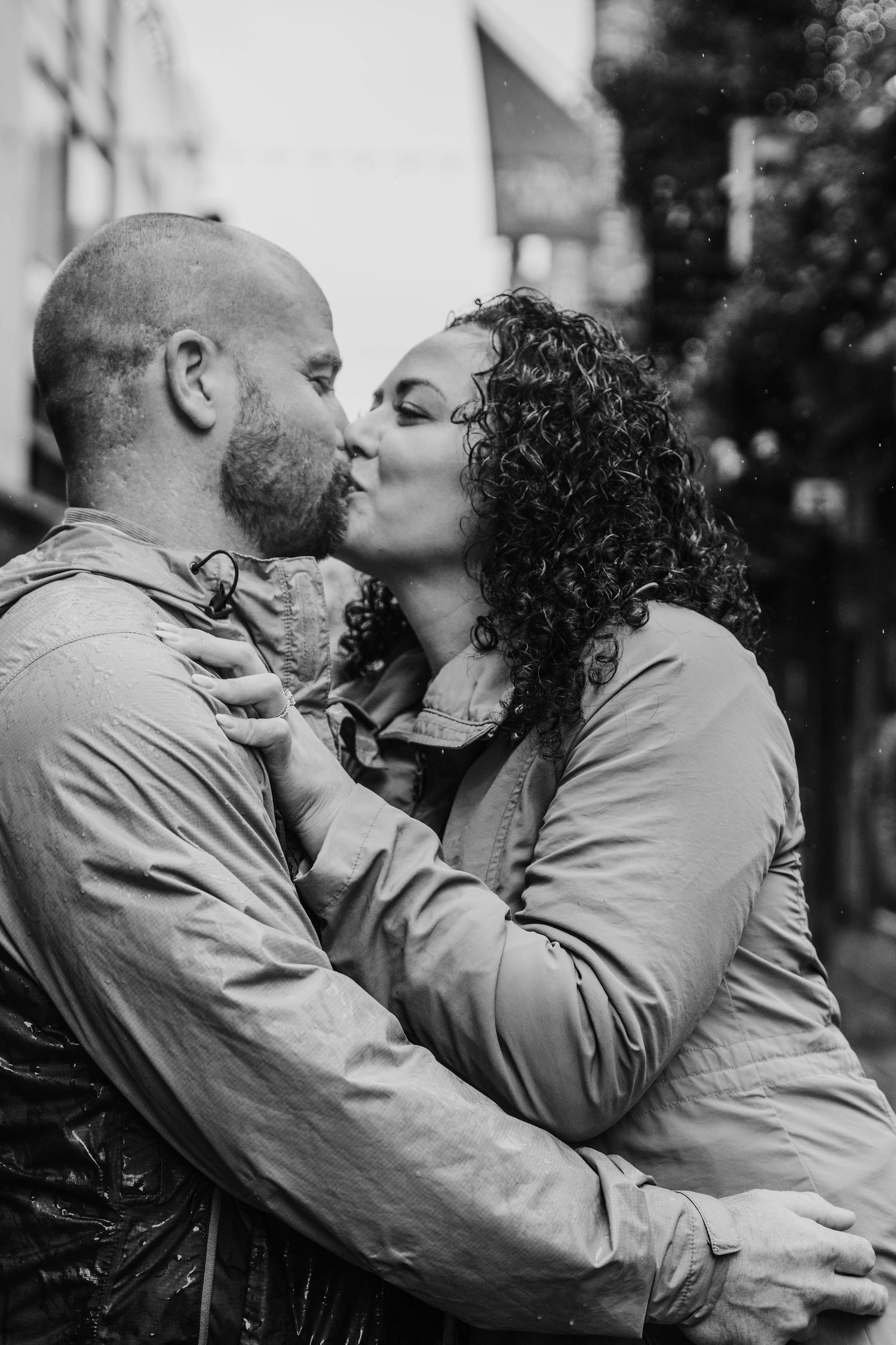 A romantic black and white photo sequence showing a couple sharing tender kisses on a park bench. Proposal Dublin Photographer