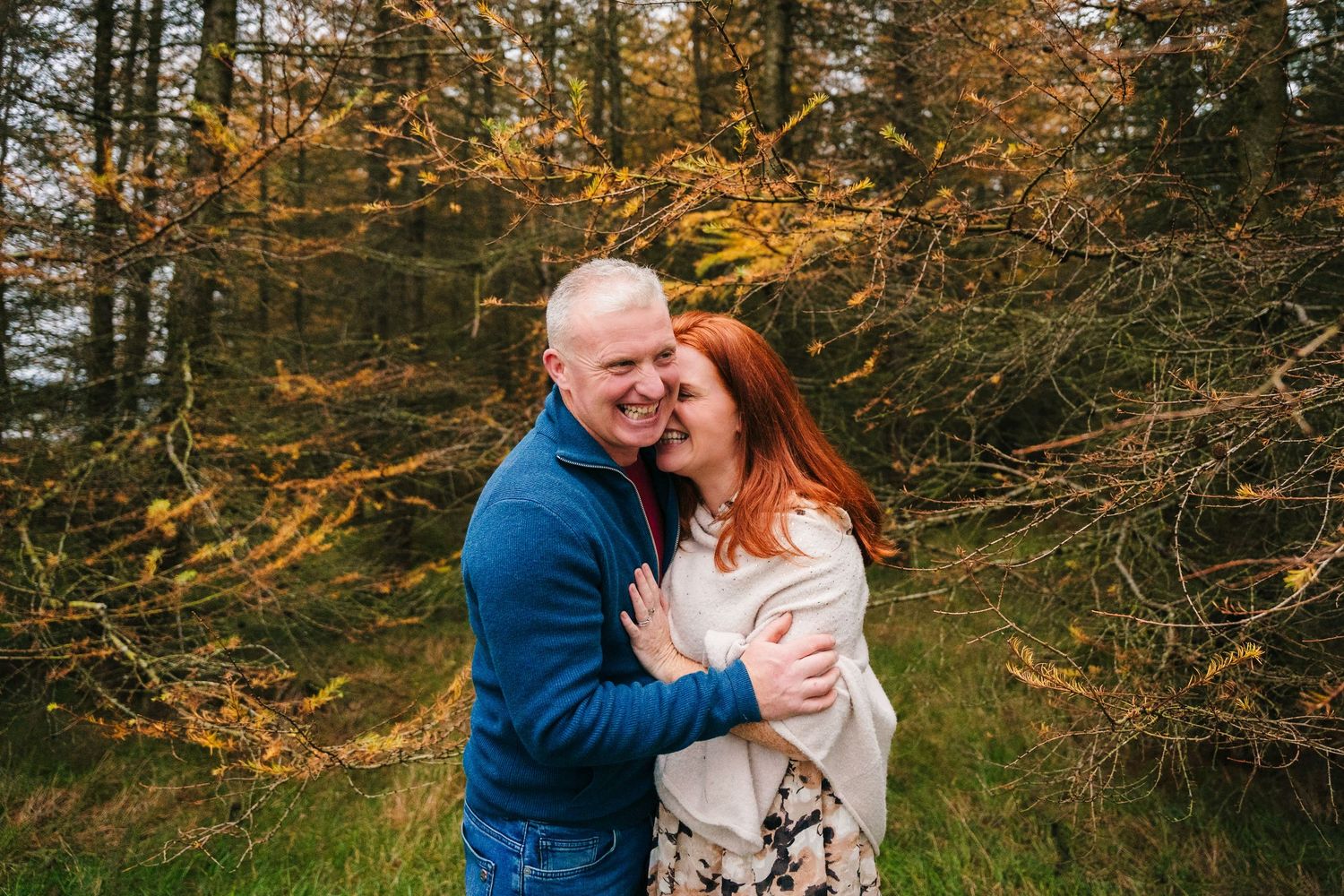 Intimate family moments captured during golden hour forest photoshoot with warm autumn colors.