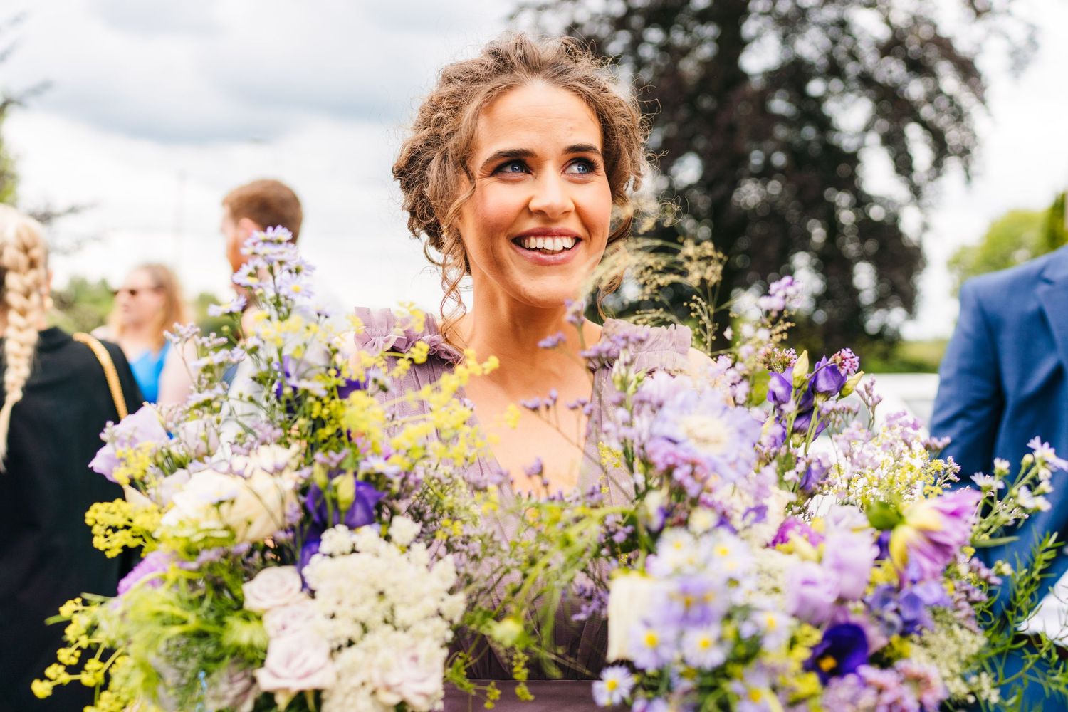 Millhouse slane wedding photographer dublin Vibrant purple and white wedding flowers arranged against a sunny outdoor backdrop.