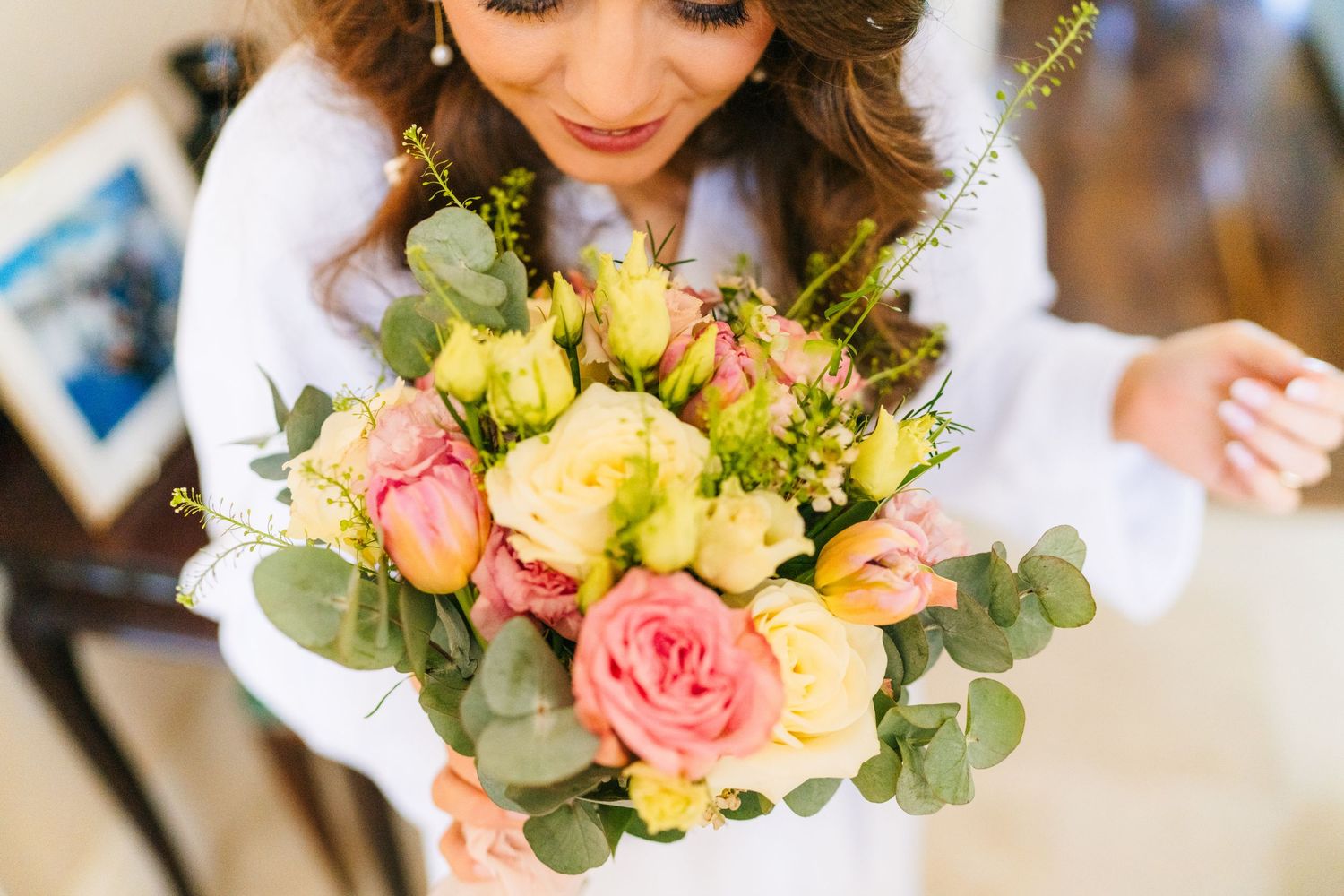 A stunning bridal bouquet featuring pink roses, eucalyptus leaves, and white flowers in soft natural lighting. Castle Leslie Wedding Photogr