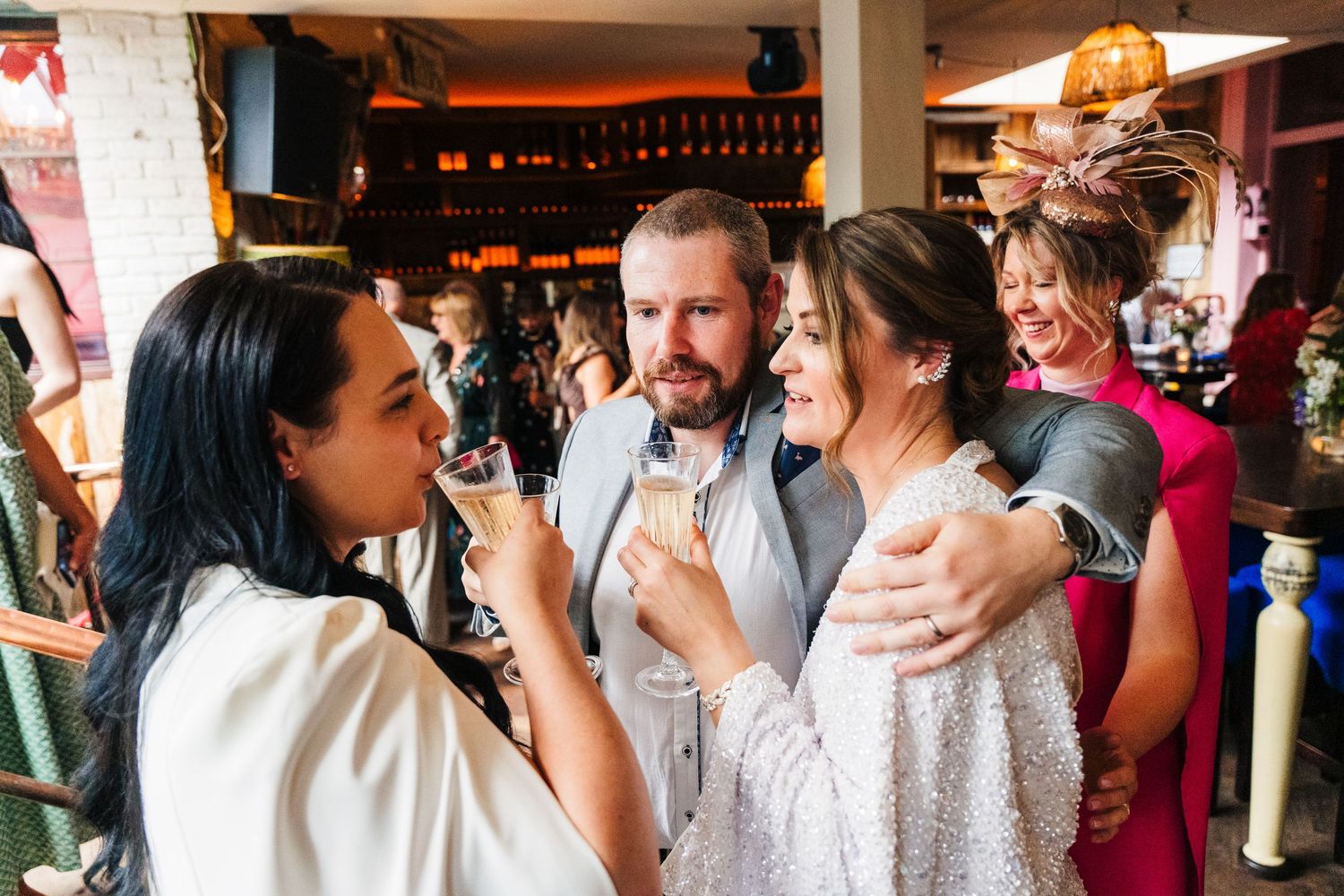 A lively celebration moment with partygoers laughing and embracing at an indoor venue. House Dublin Wedding Photographer