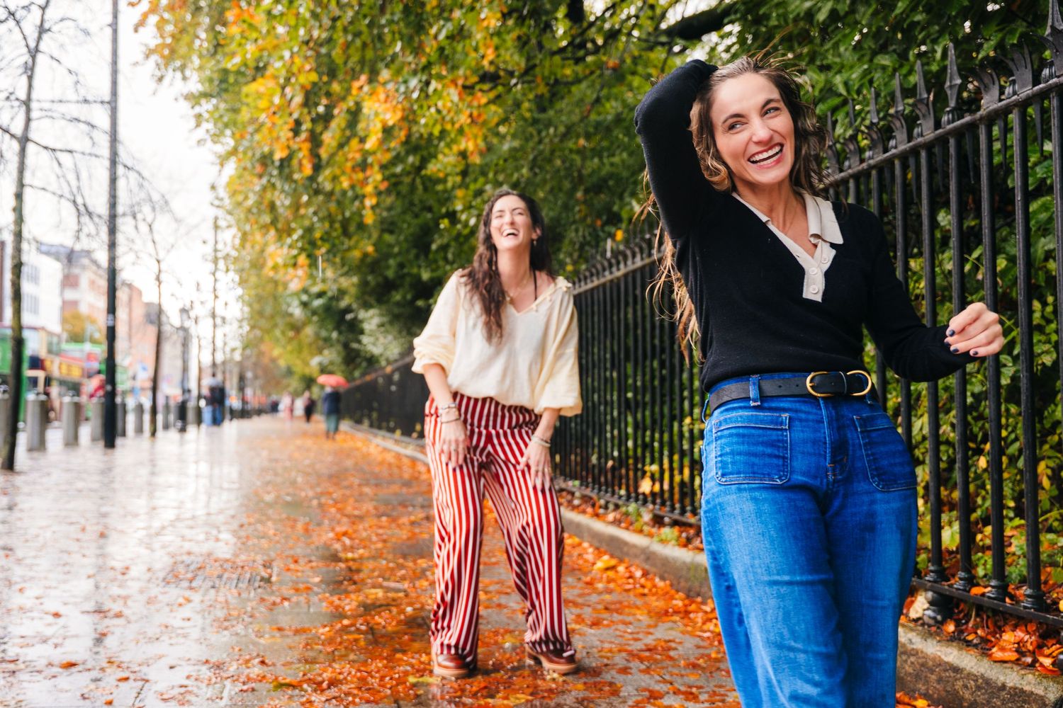Autumn street scene with colorful fall foliage and people walking along an iron fence. professional headshots dublin photographer