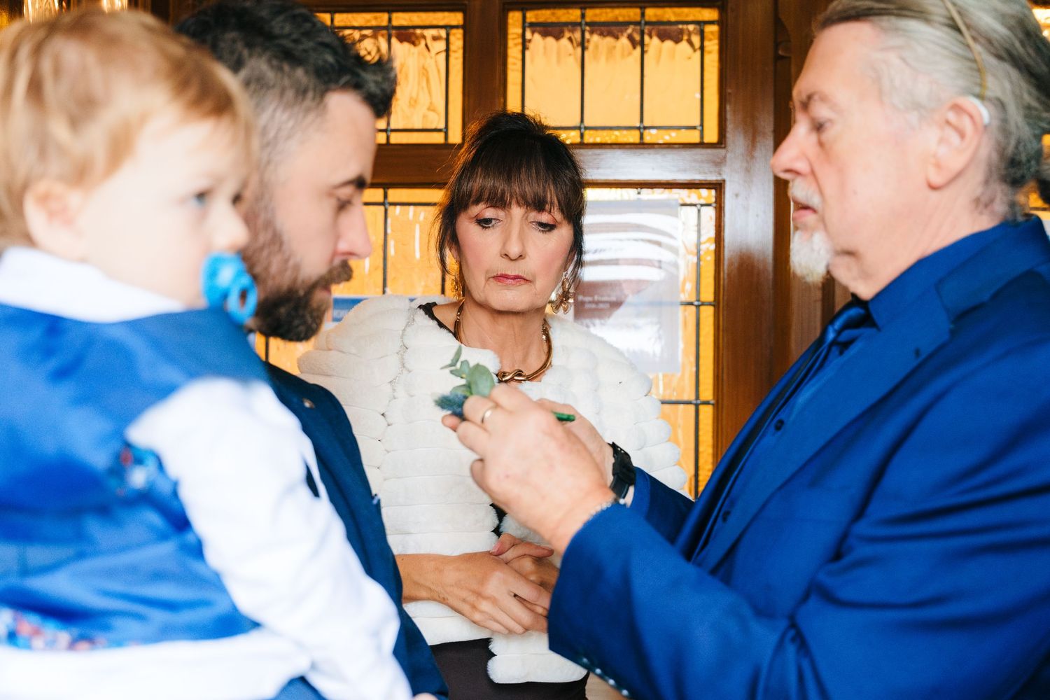 Wedding ceremony guests embrace and share emotional moments in a church setting.