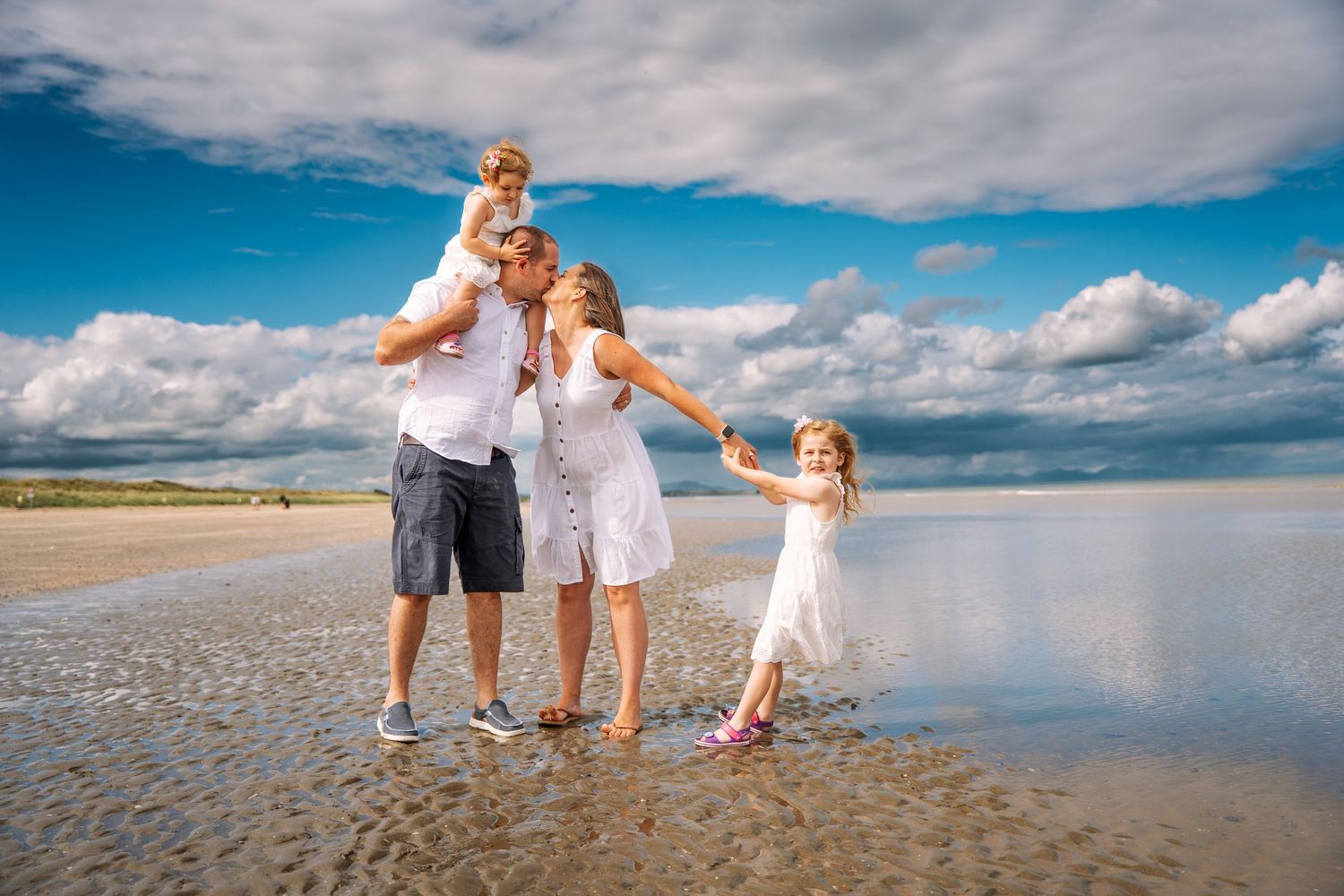 Beautiful family vacation photos with people walking and playing together on a scenic beach under blue cloudy skies. family PHOTOGRAPHER Dub