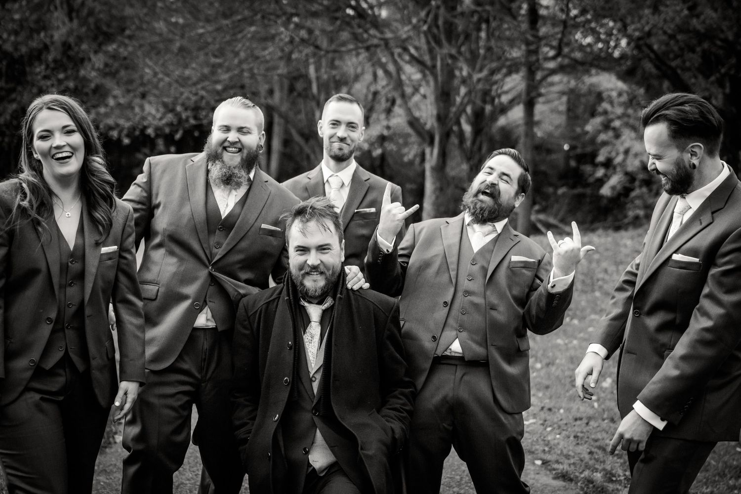 Black and white photo of a joyful wedding party laughing together outdoors in formal attire. Wedding PHOTOGRAPHER Dublin