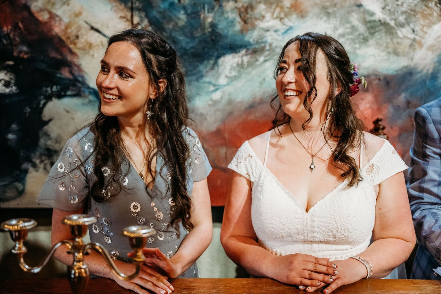 Wedding party members enjoying drinks and conversation against a colorful abstract backdrop. Wedding photographer Dublin