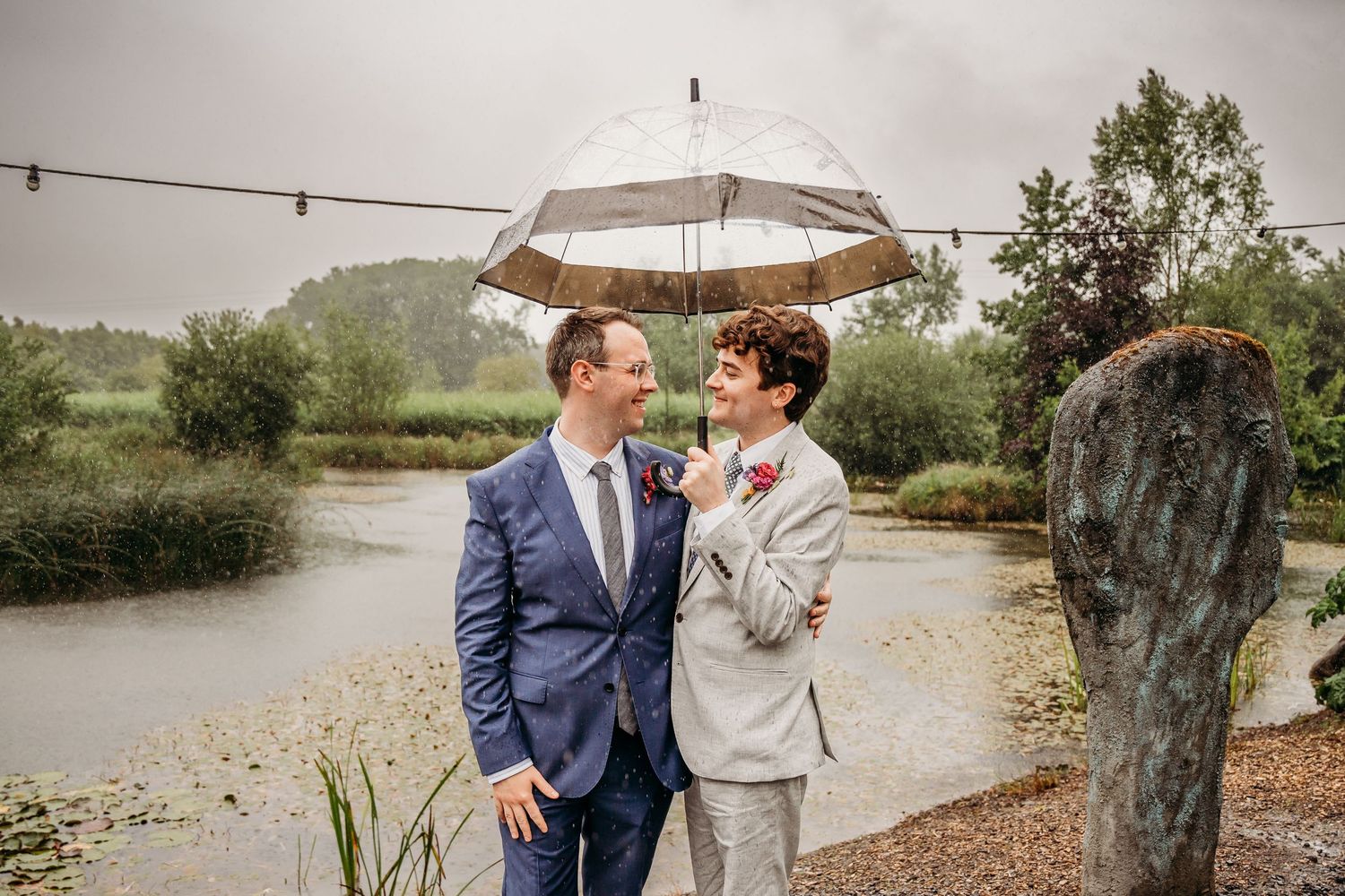 Couple shares intimate moment under clear umbrella on rainy wedding day. Wedding photographer Dublin