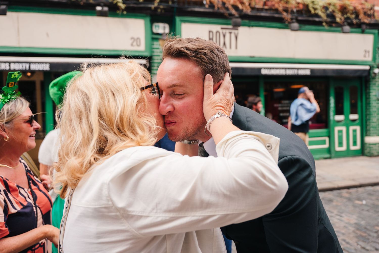 A tender moment shared between two people outside a traditional Irish pub building. Same sex wedding PHOTOGRAPHER Dublin
