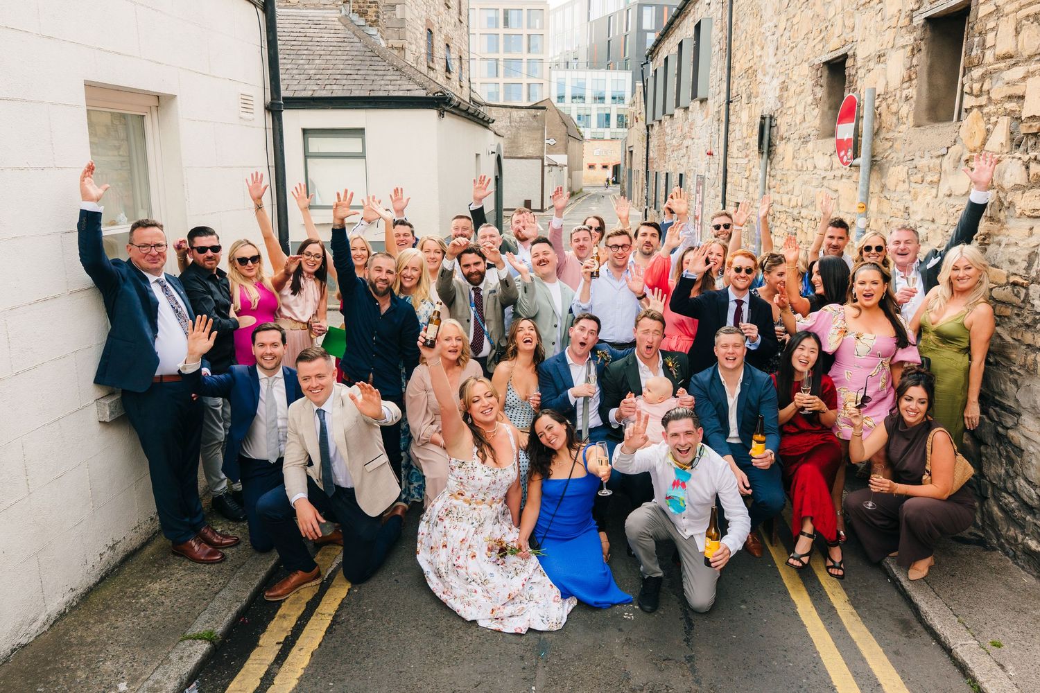 Large group of wedding guests pose together on city street for fun photo. Same sex wedding PHOTOGRAPHER Dublin