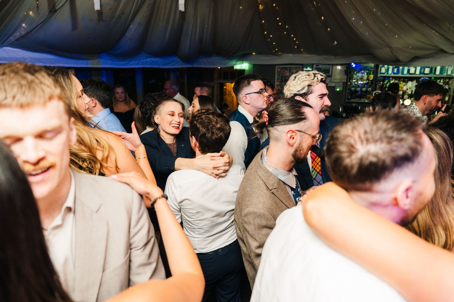 Millhouse slane wedding photographer dublin Energetic wedding reception dance party with guests under dimmed lighting.