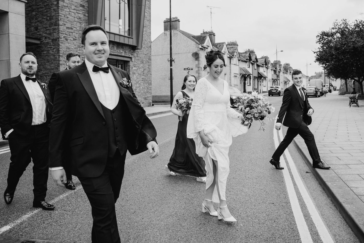 Black and white candid street photography of wedding guests walking outdoors.Wedding Photography Trim Castle Ireland