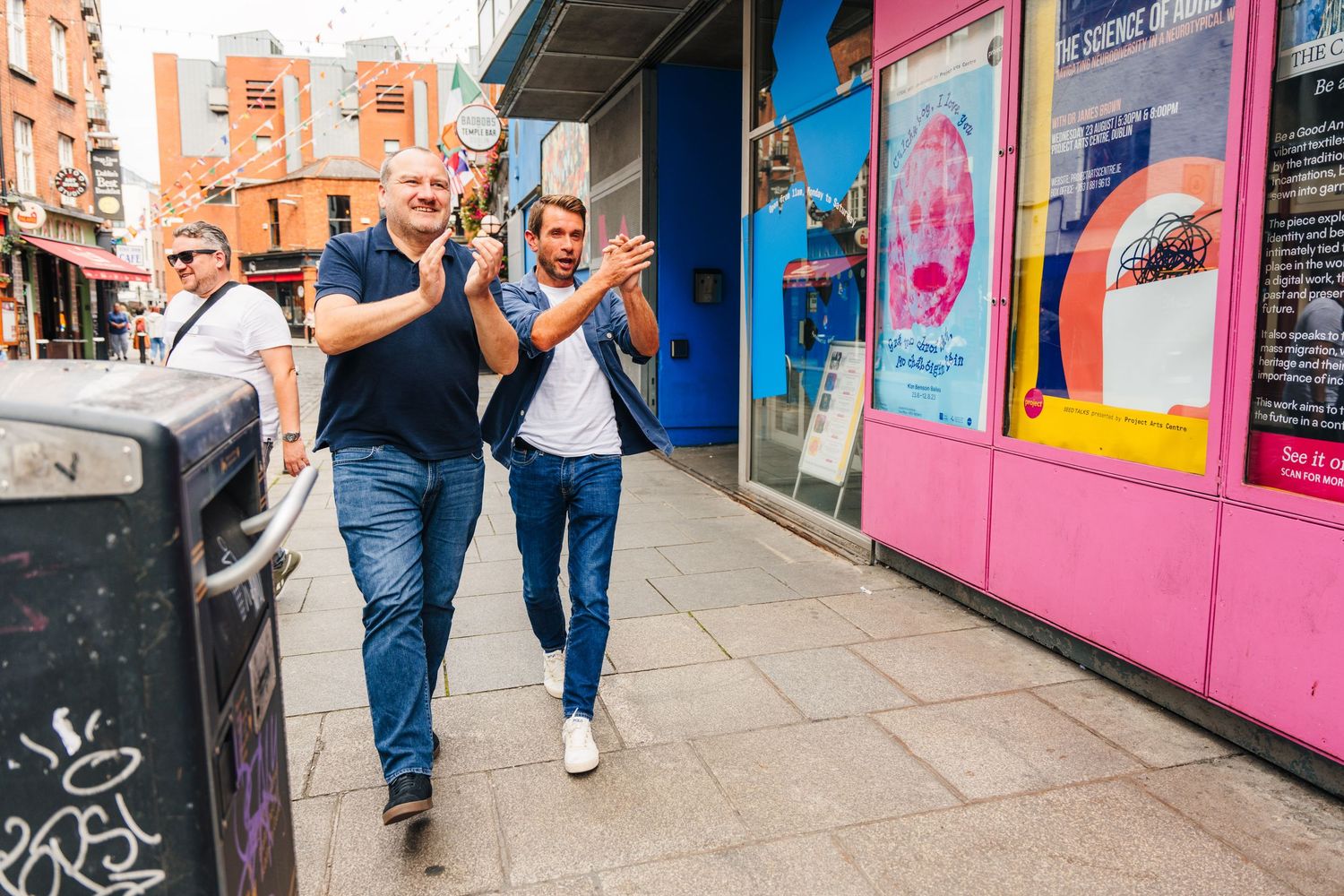 Friends walking past colorful storefront murals on urban street. PHOTOGRAPHER Dublin Ireland Wedding