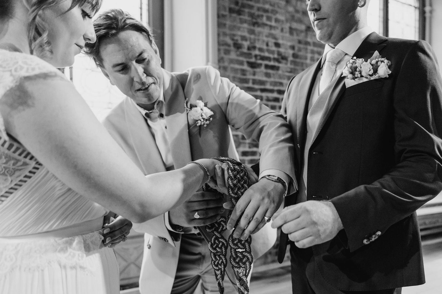Black and white close-up of hands during an intimate wedding ceremony moment. PHOTOGRAPHER Dublin Ireland Wedding