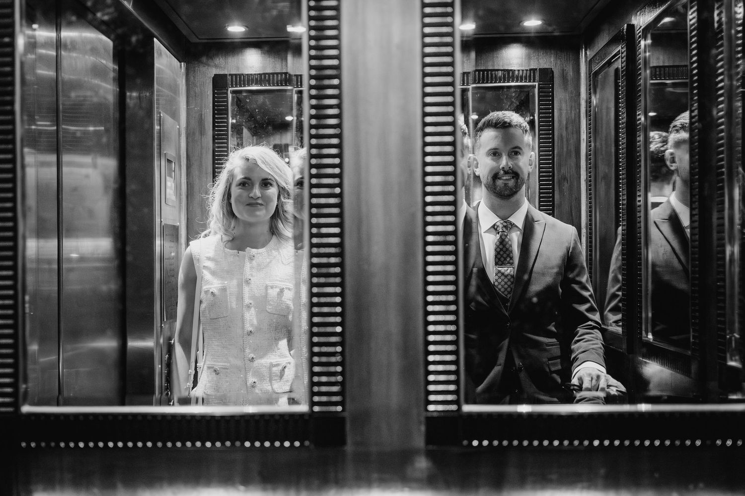 Artistic black and white photo of wedding couple standing in mirrored elevator doorways. City Hall Dublin wedding photogrAPher