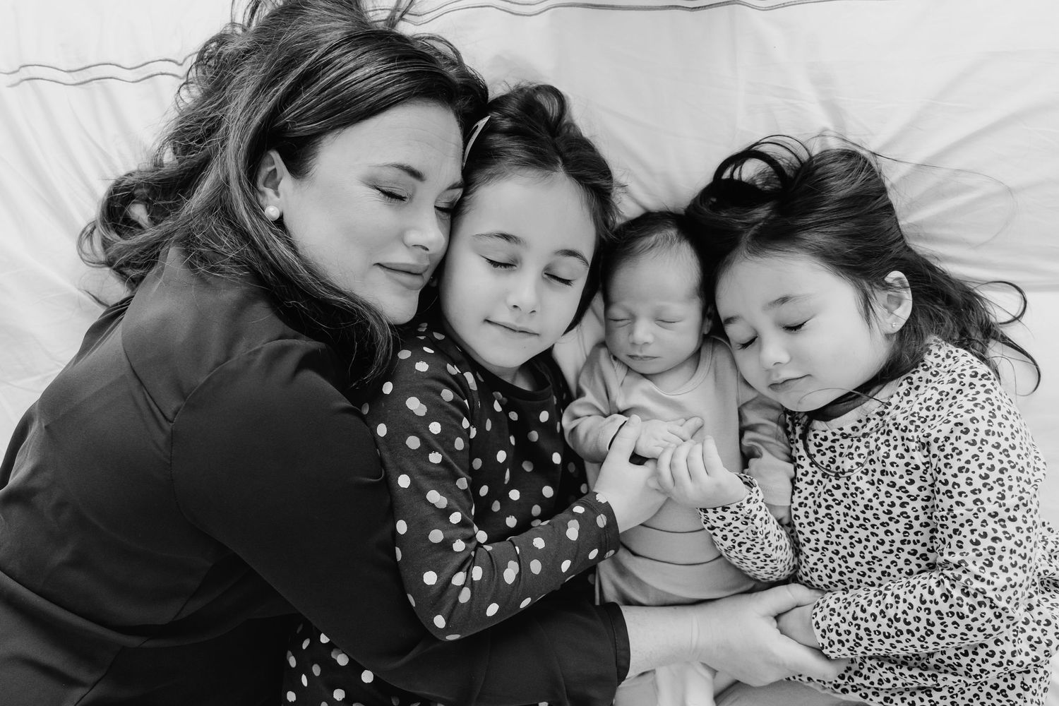A black and white photo collage showing tender family moments of rest and cuddling on white bedding. Family PHOTOGRAPHER Dublin