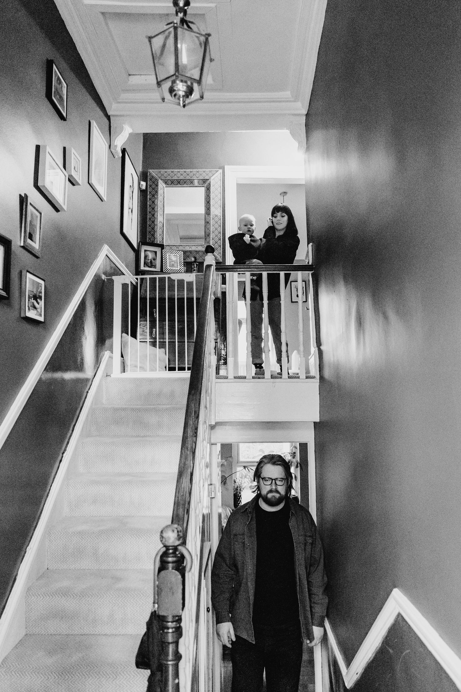 Black and white photographs showing a hallway with stairs and wall art in sequence.  Family PHOTOGRAPHER Dublin