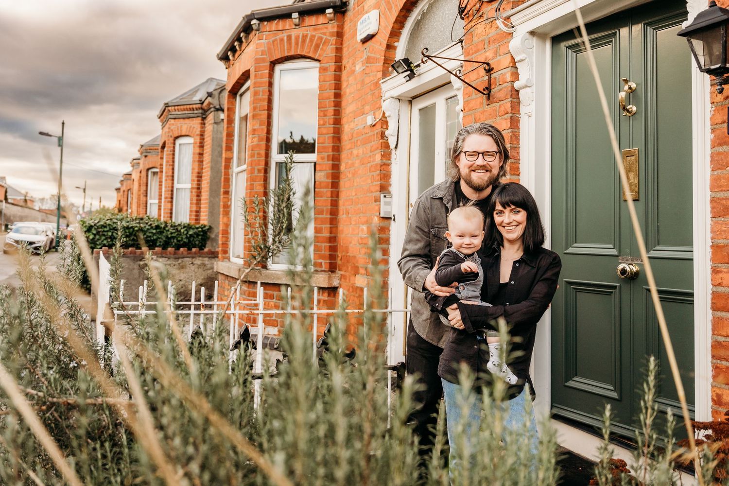 A series of casual lifestyle shots taken outside a traditional red brick townhouse with green shutters.  Family PHOTOGRAPHER Dublin