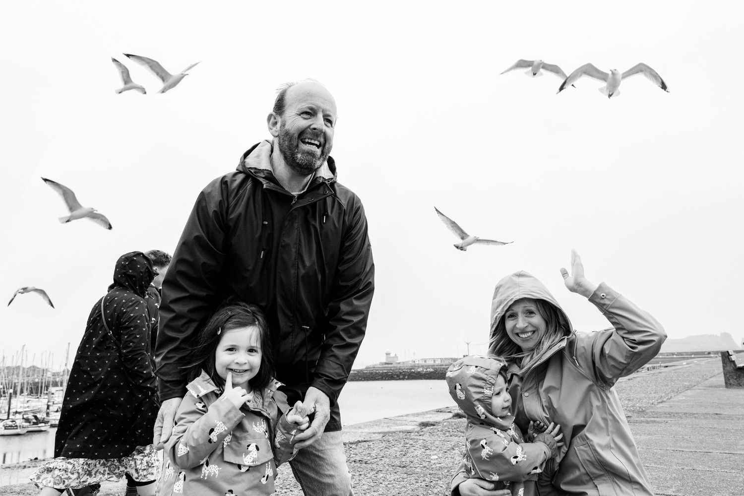 Family sharing a joyful moment while feeding seagulls at the seaside. PHOTOGRAPHER Dublin