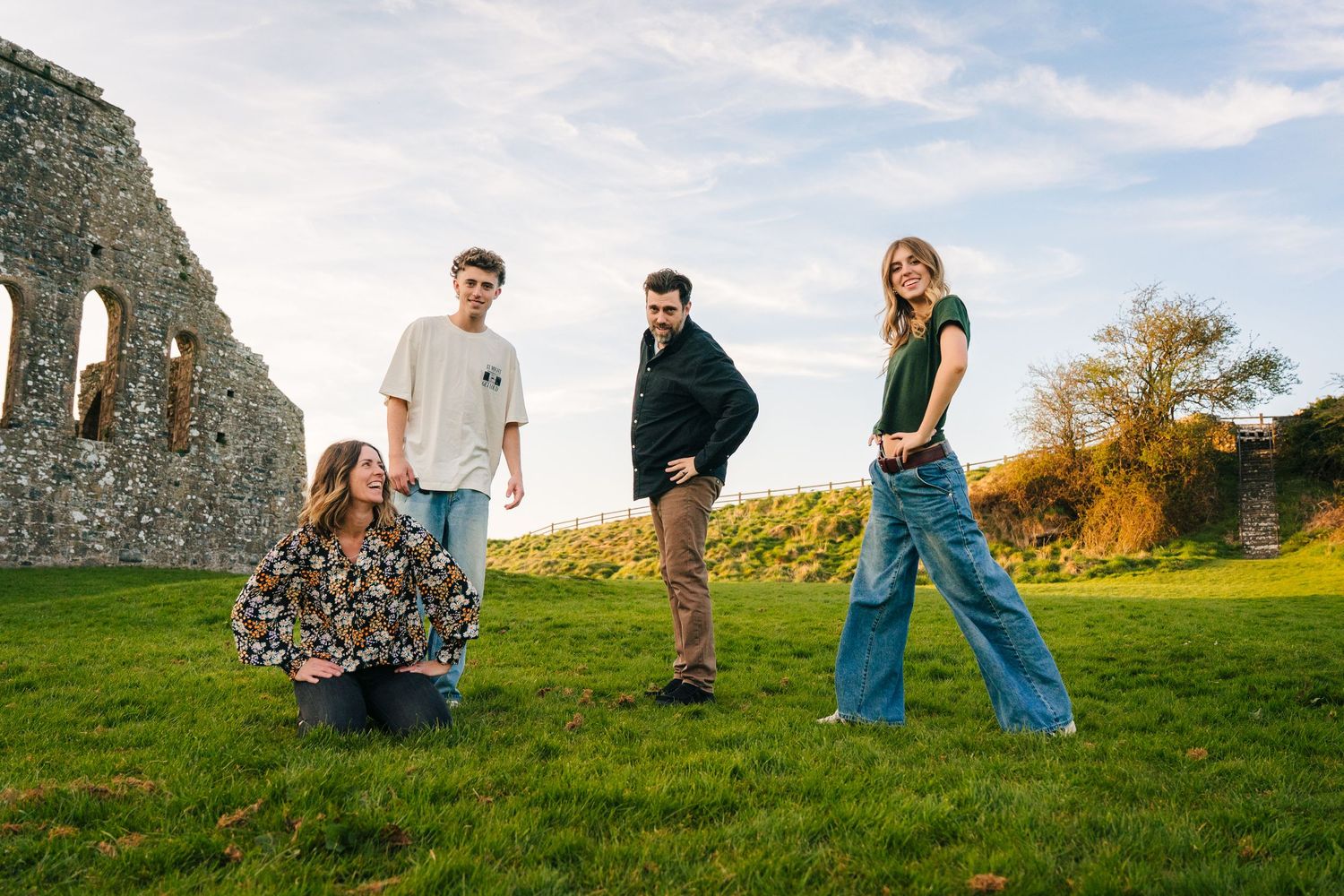 Group enjoying a sunny day on grass near ancient stone ruins. Photographer Ireland dublin