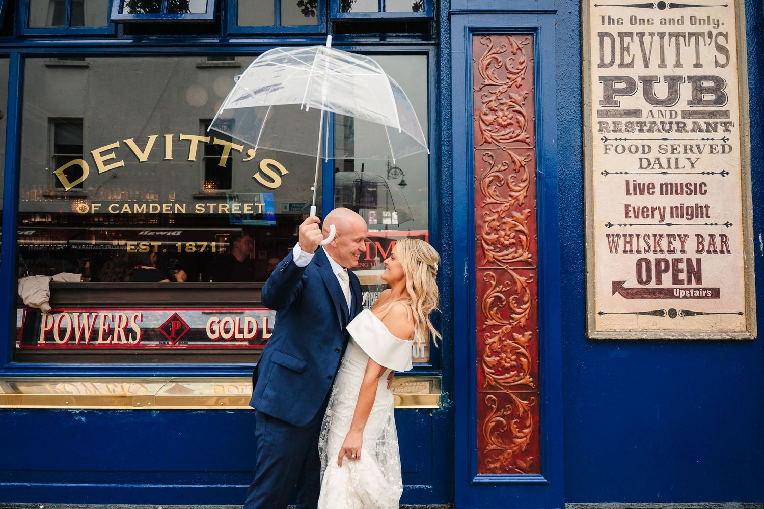 Classic pub storefront with blue trim and charming signage on a rainy day. The Dean Dublin Wedding Photographer