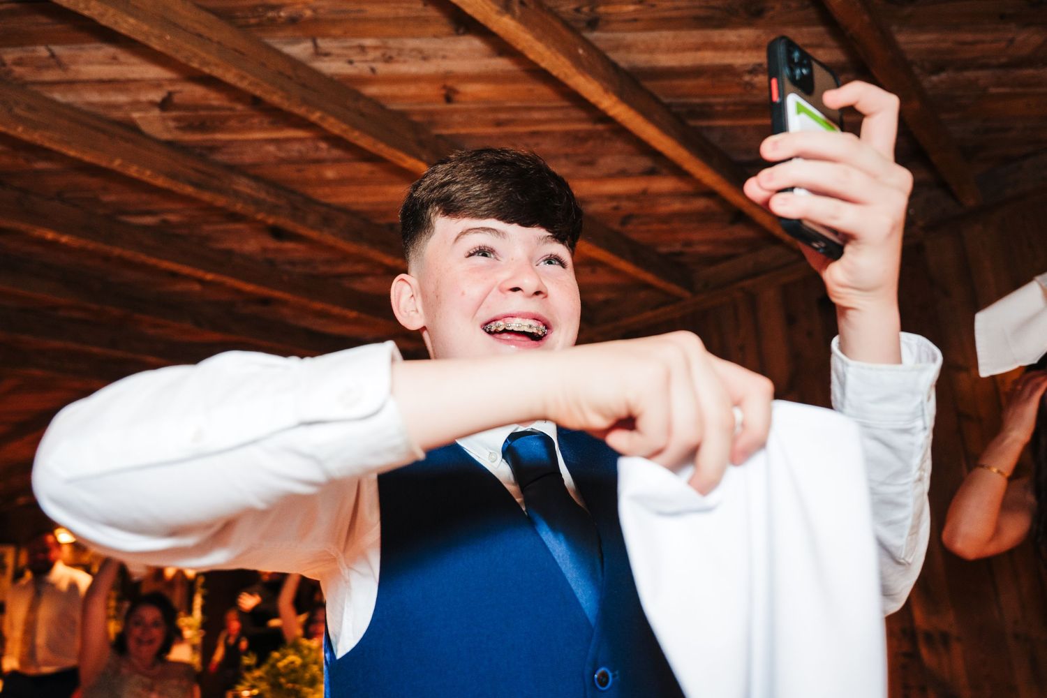 Wedding guests dancing and celebrating energetically at a rustic indoor reception. The Dean Dublin Wedding Photographer