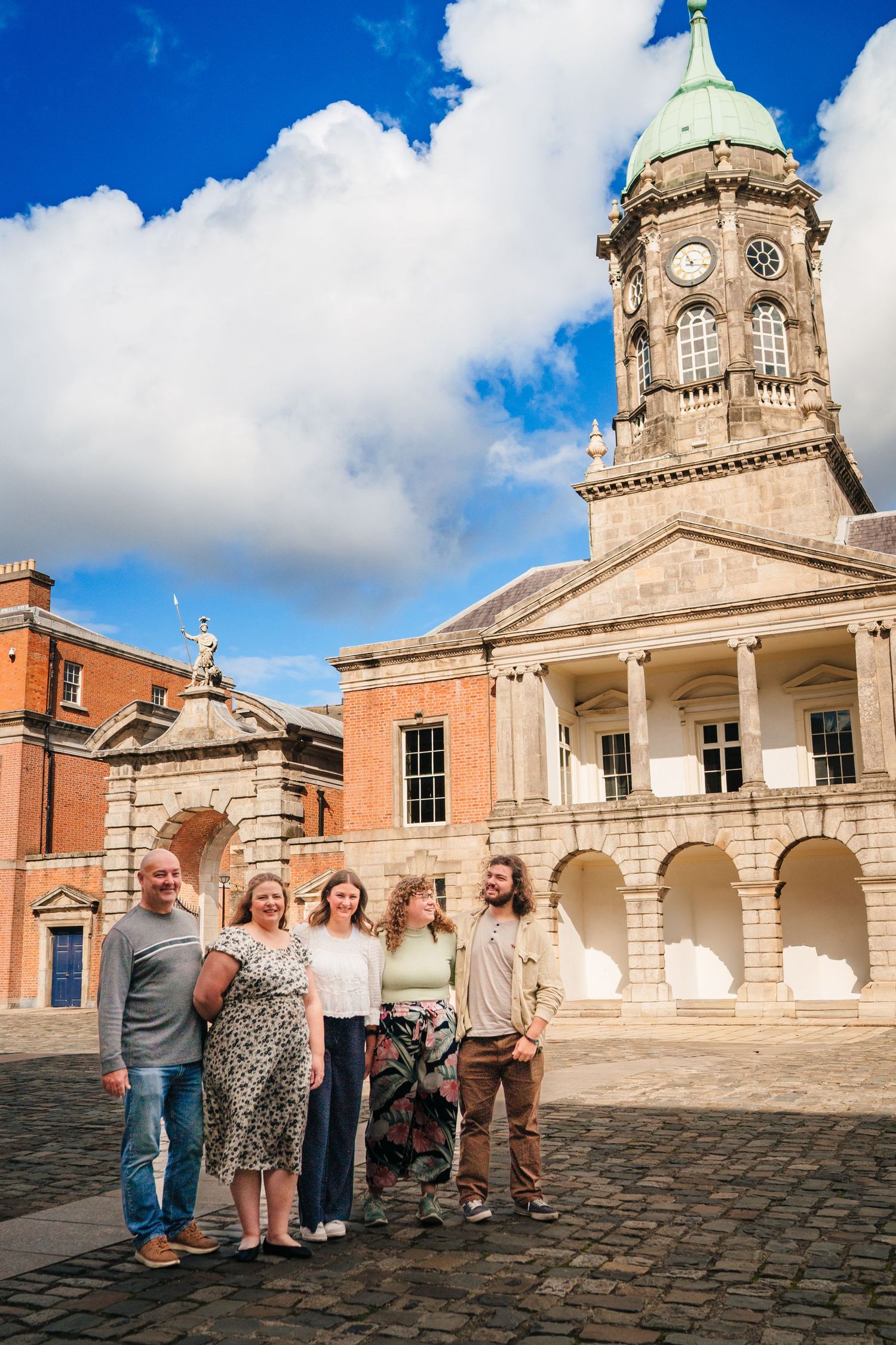 A group enjoying a sunny day outside a historic building with columns and a dome against blue skies. Family photographer Dublin Ireland