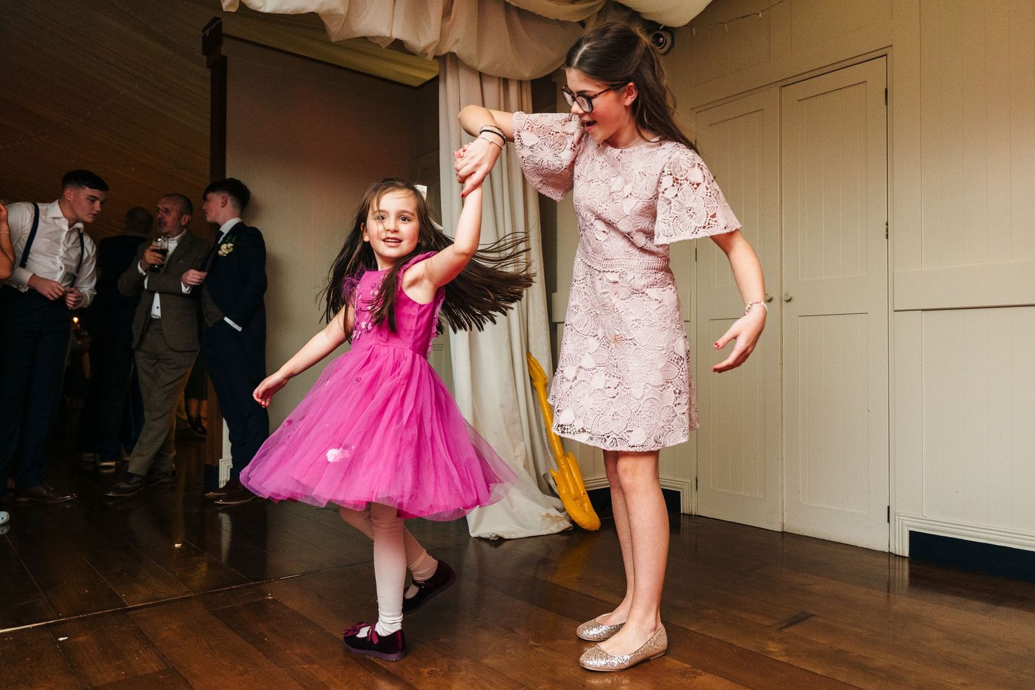 Children dancing and twirling in formal attire at a wedding reception.  Virginia Park Lodge Wedding Photographer Cavan Dublin Ireland