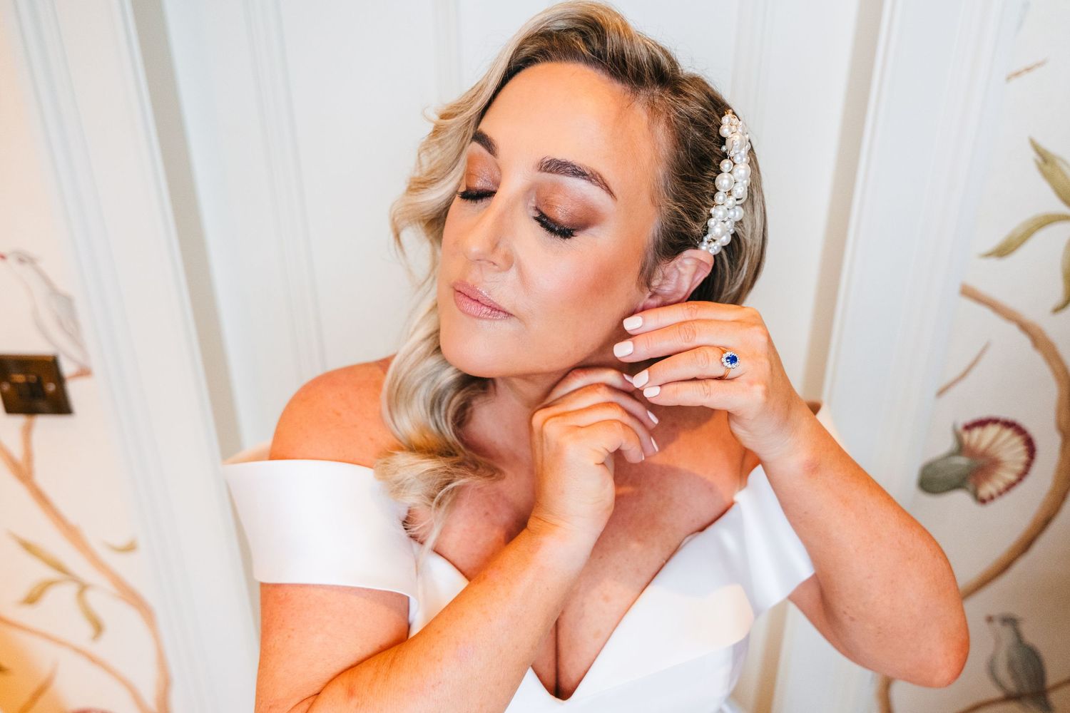 A close-up shot showing final touches being made with delicate jewelry and makeup preparations. Virginia Park Lodge Wedding Photographer Dub
