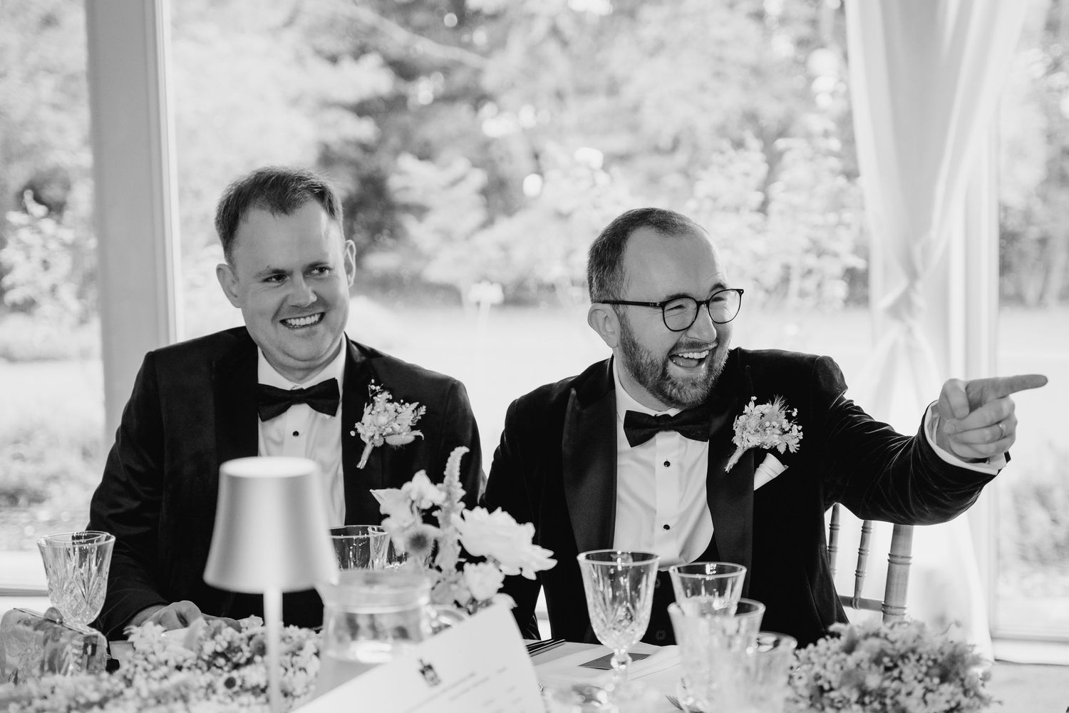 Black and white image of formal dining setup with elegant table settings and floral centerpieces. LGBTQ Ashley Park Wedding Photographer