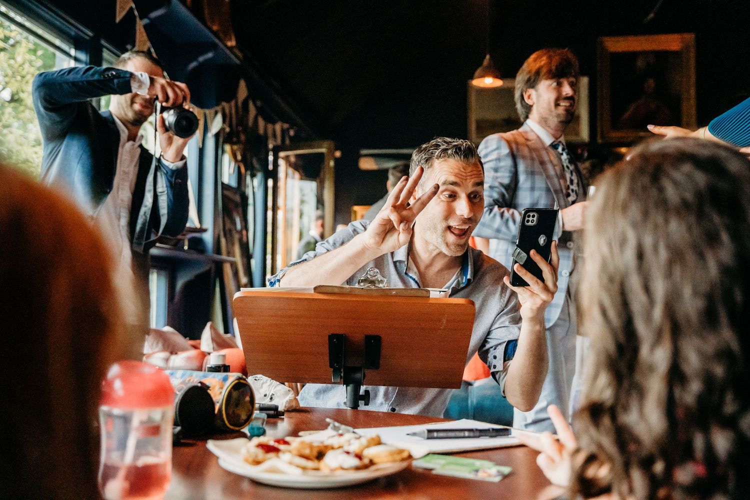 Casual dining scene with guests enjoying conversation and food at a restaurant table. Wedding photographer Dublin