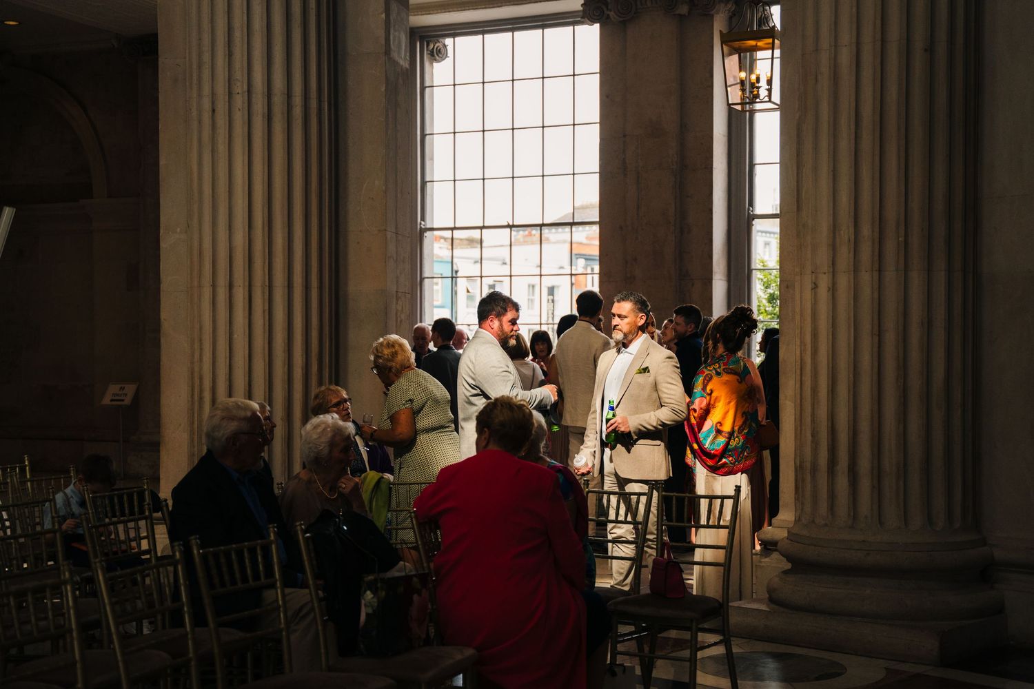An elegant wedding venue interior with classical columns and rows of chairs.  city hall dublin wedding photos