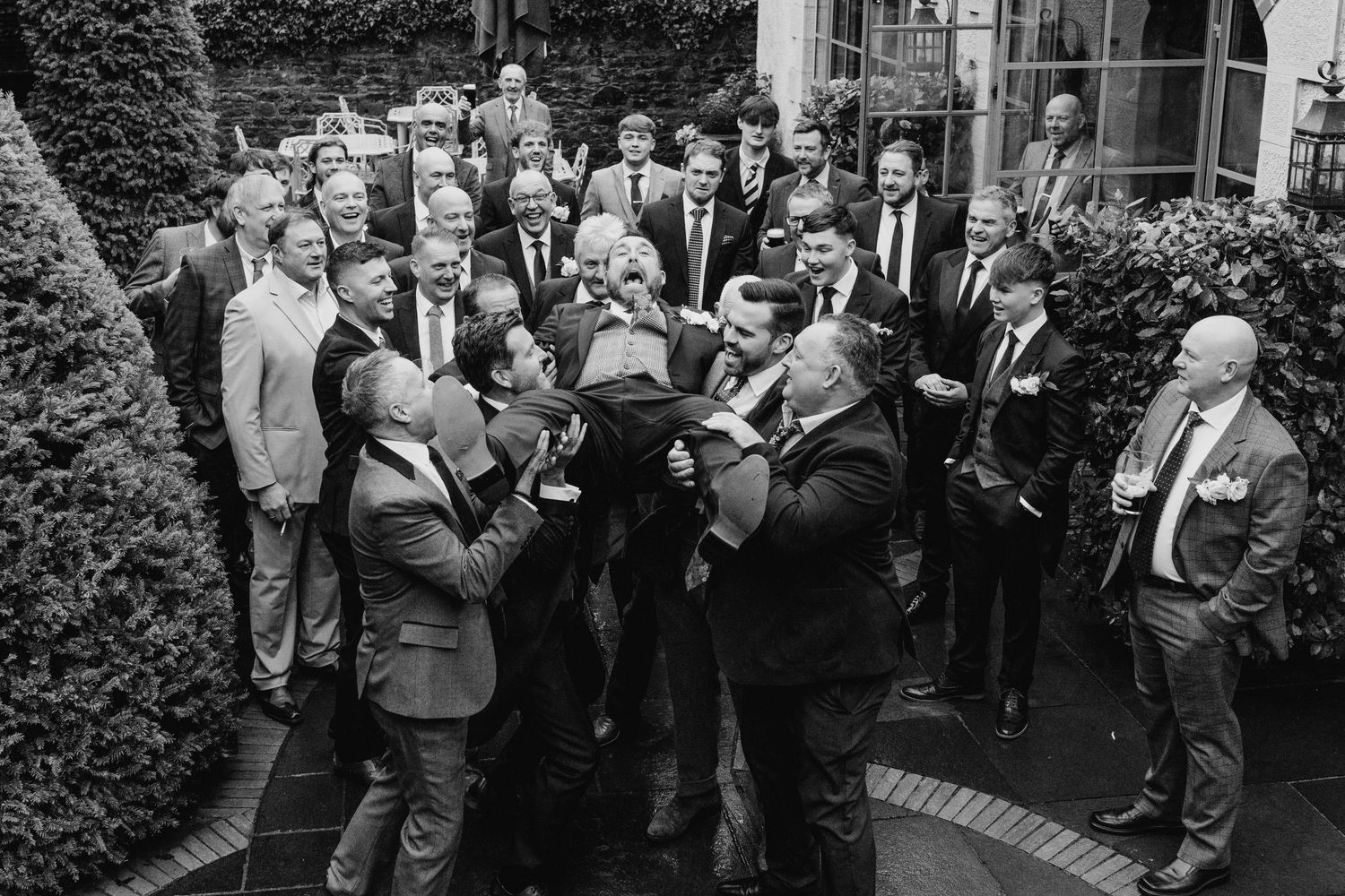Crowd of formally dressed guests gathered outside for a wedding celebration.  Virginia Park Lodge Wedding Photographer Cavan Dublin Ireland