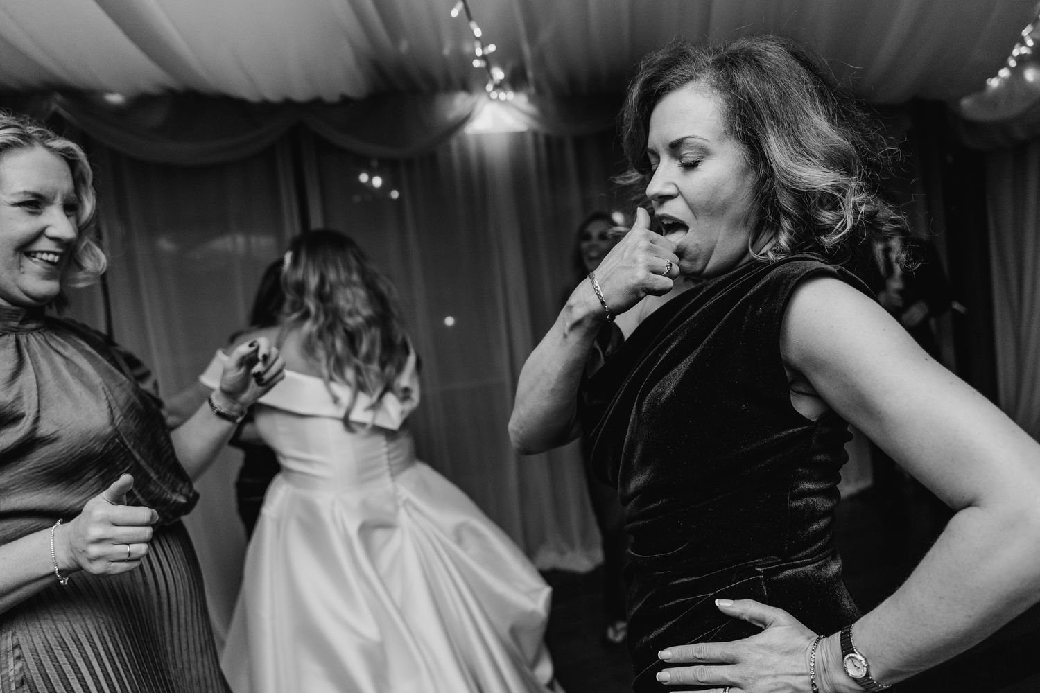 Wedding guests dancing and enjoying themselves at a reception under fairy lights.  Virginia Park Lodge Wedding Photographer Cavan Dublin Ire