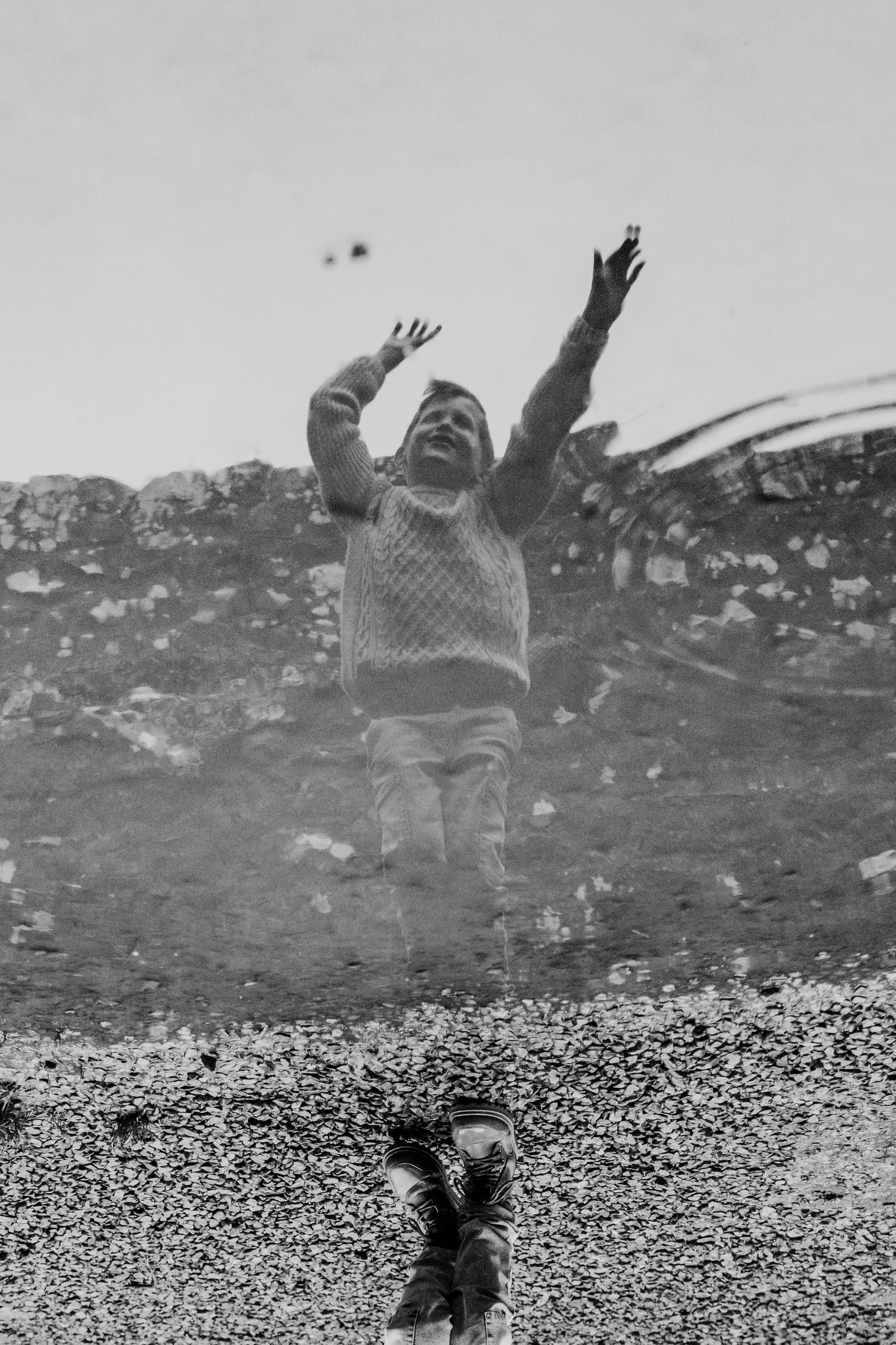 A sequence of black and white images showing someone falling backwards with arms outstretched against a rocky landscape. family PHOTOGRAPHER