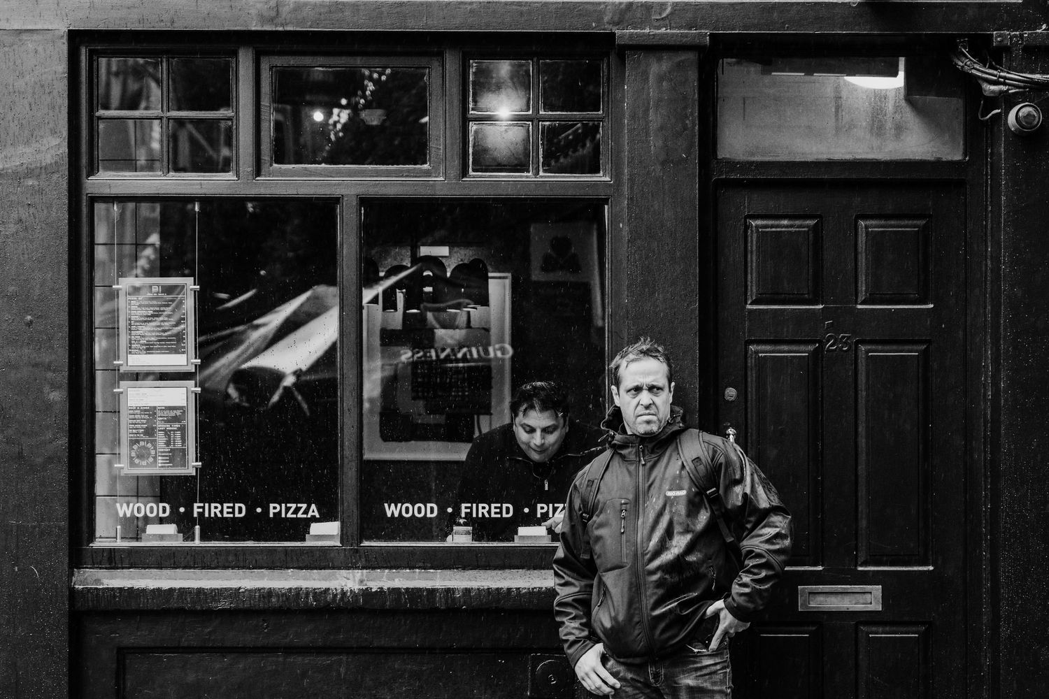 A black and white photograph of a storefront in London showing multiple doorways and windows at night. Proposal Dublin Photographer