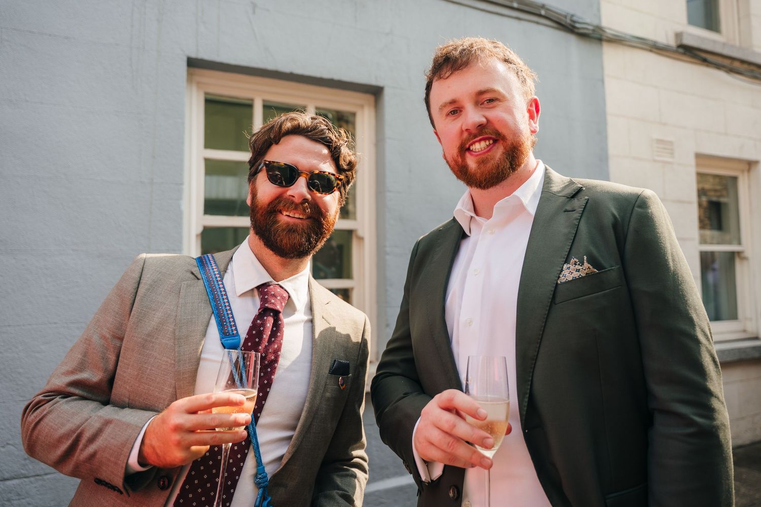 Group enjoying drinks and conversation outside building.Same sex wedding PHOTOGRAPHER Dublin