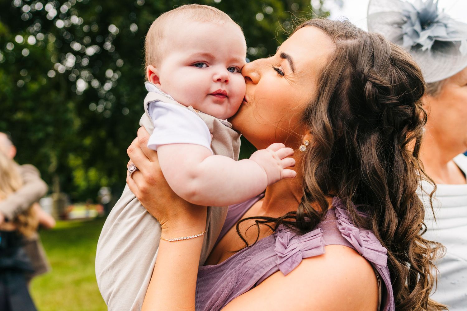 Millhouse slane wedding photographer dublin Tender moment between cherubic baby and guest at outdoor wedding celebration.