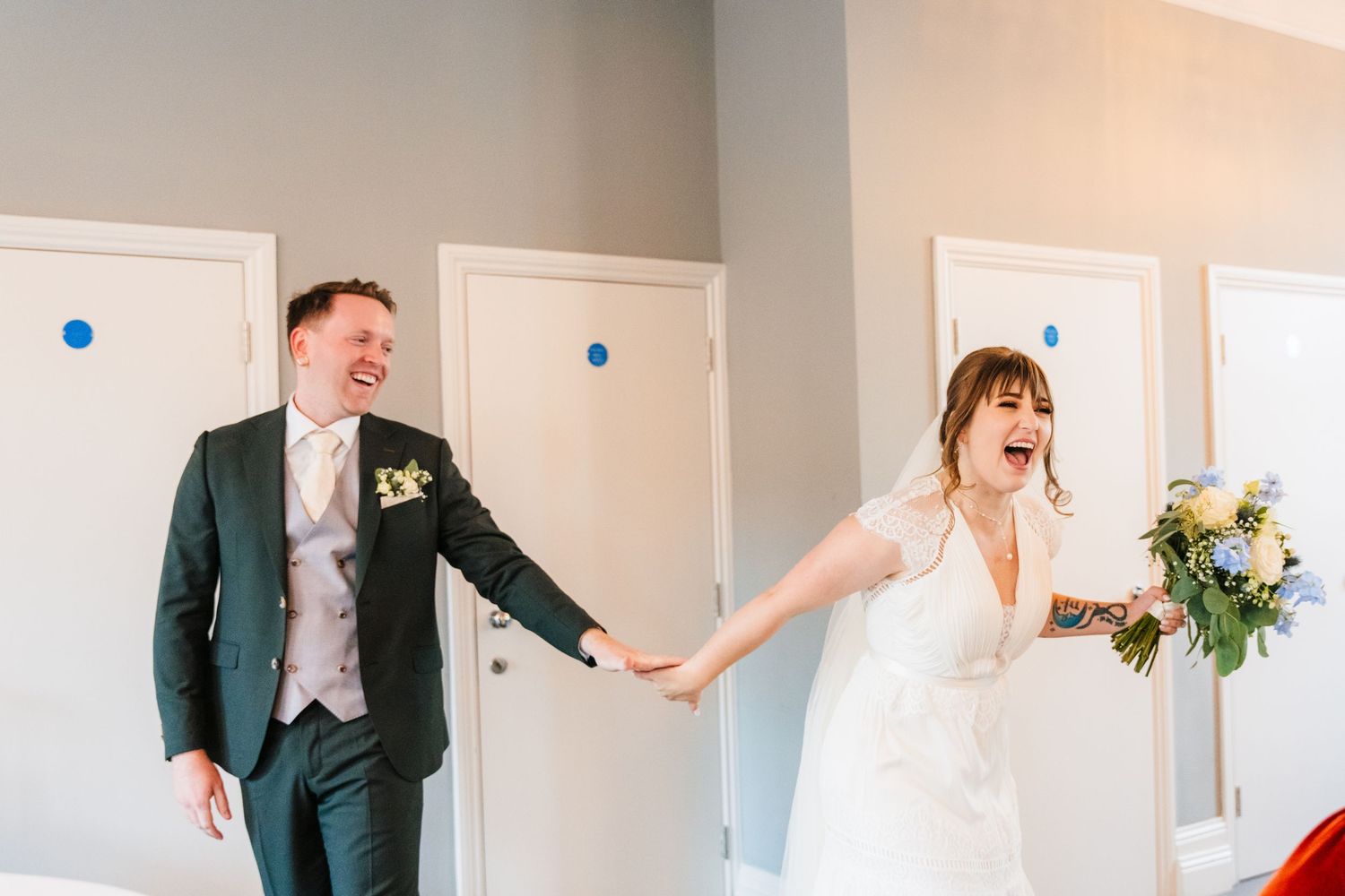 A joyful moment captured in a bright hallway during a wedding celebration. PHOTOGRAPHER Dublin Ireland Wedding