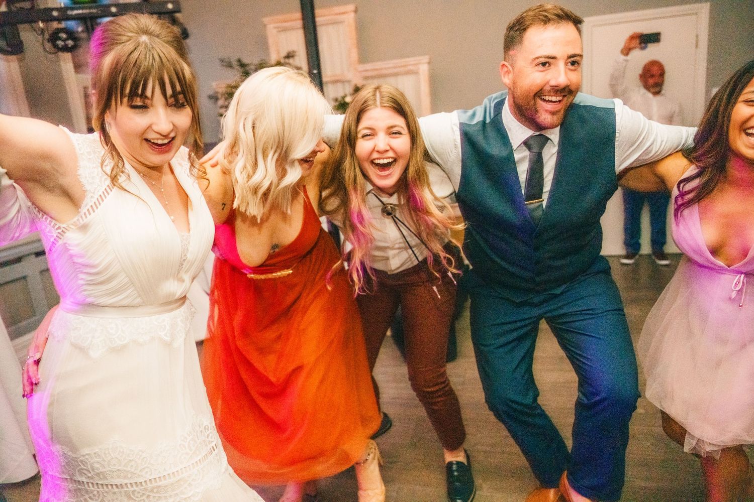 Wedding guests dance and celebrate with energetic moves on a lively dance floor. PHOTOGRAPHER Dublin Ireland Wedding