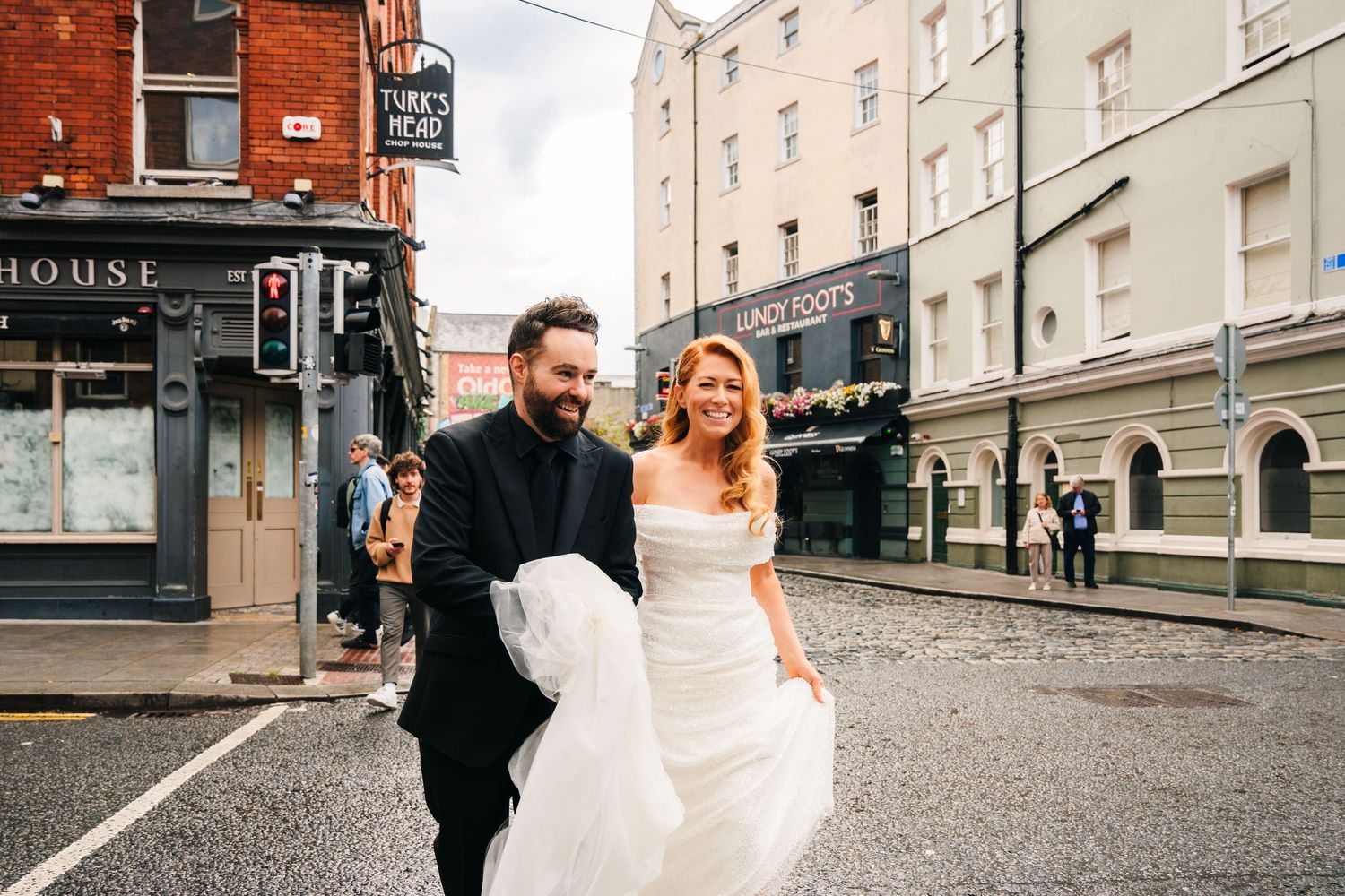 Wedding couple walking together on urban street with historic buildings in background.  city hall dublin wedding photos