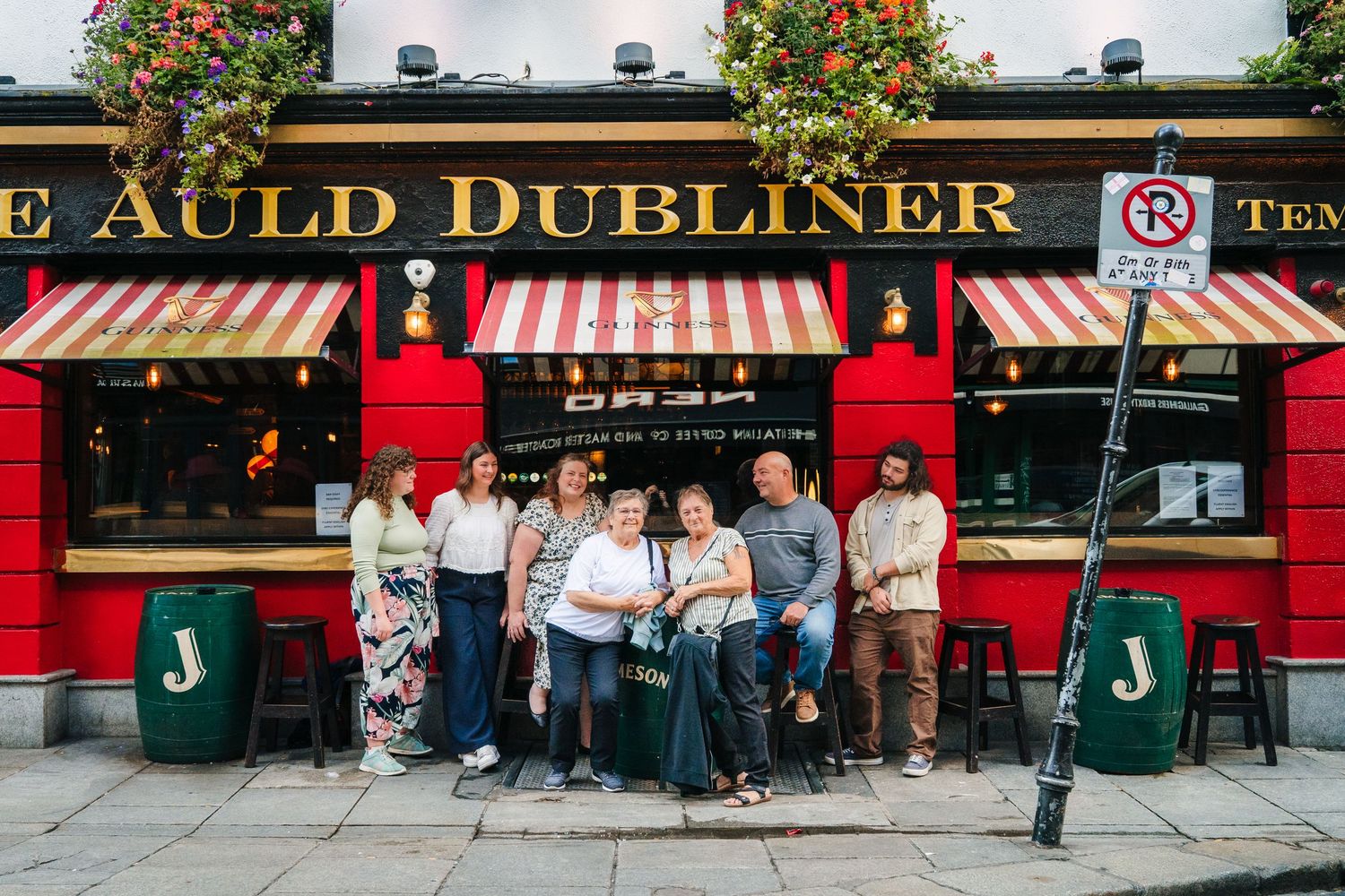 The iconic red façade of The Auld Dubliner Irish pub exterior with striped awnings on a busy city street. Family photographer Dublin Ireland