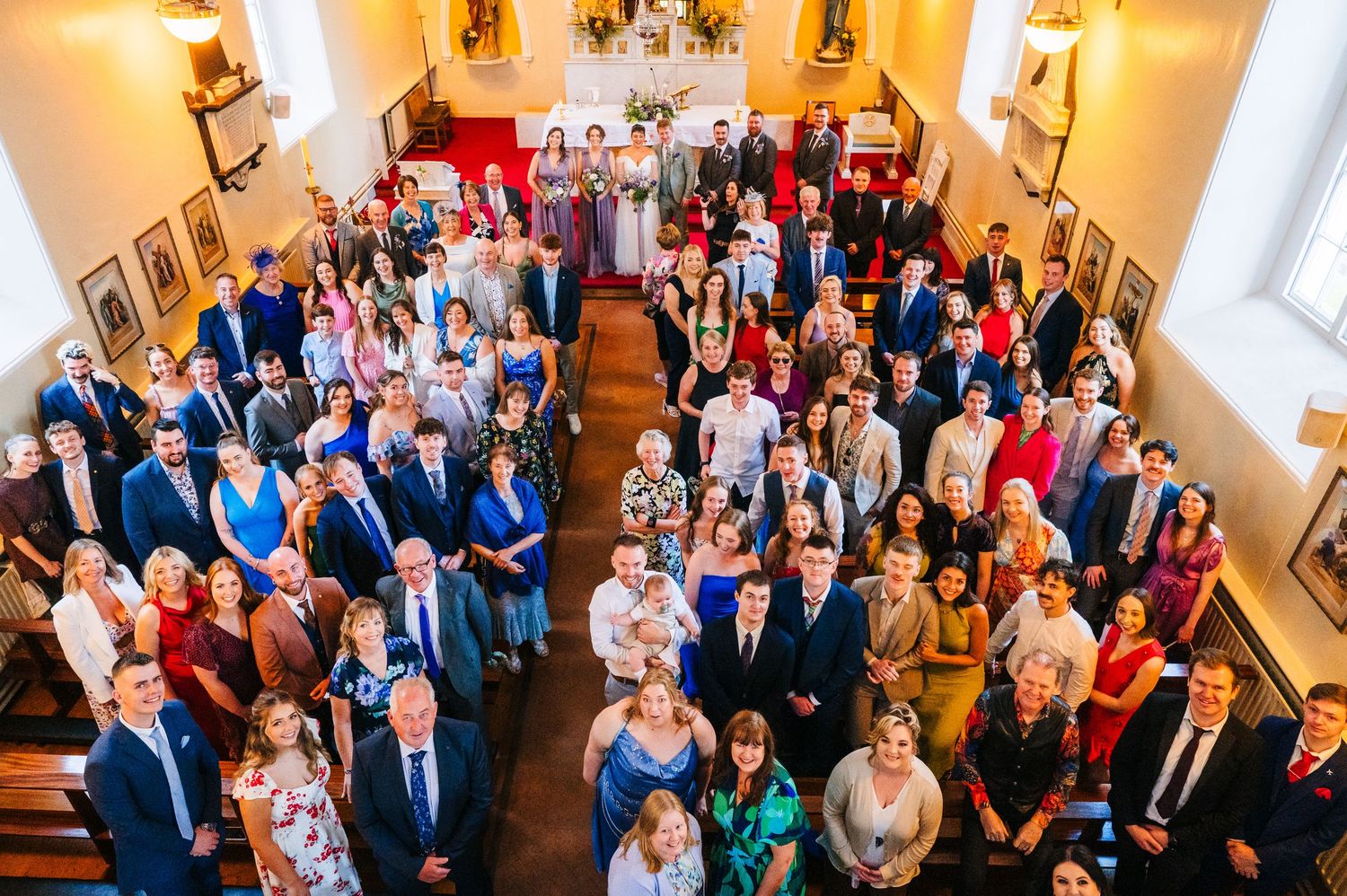 Millhouse slane wedding photographer dublin Overhead view of wedding guests gathered in ornate church sanctuary.