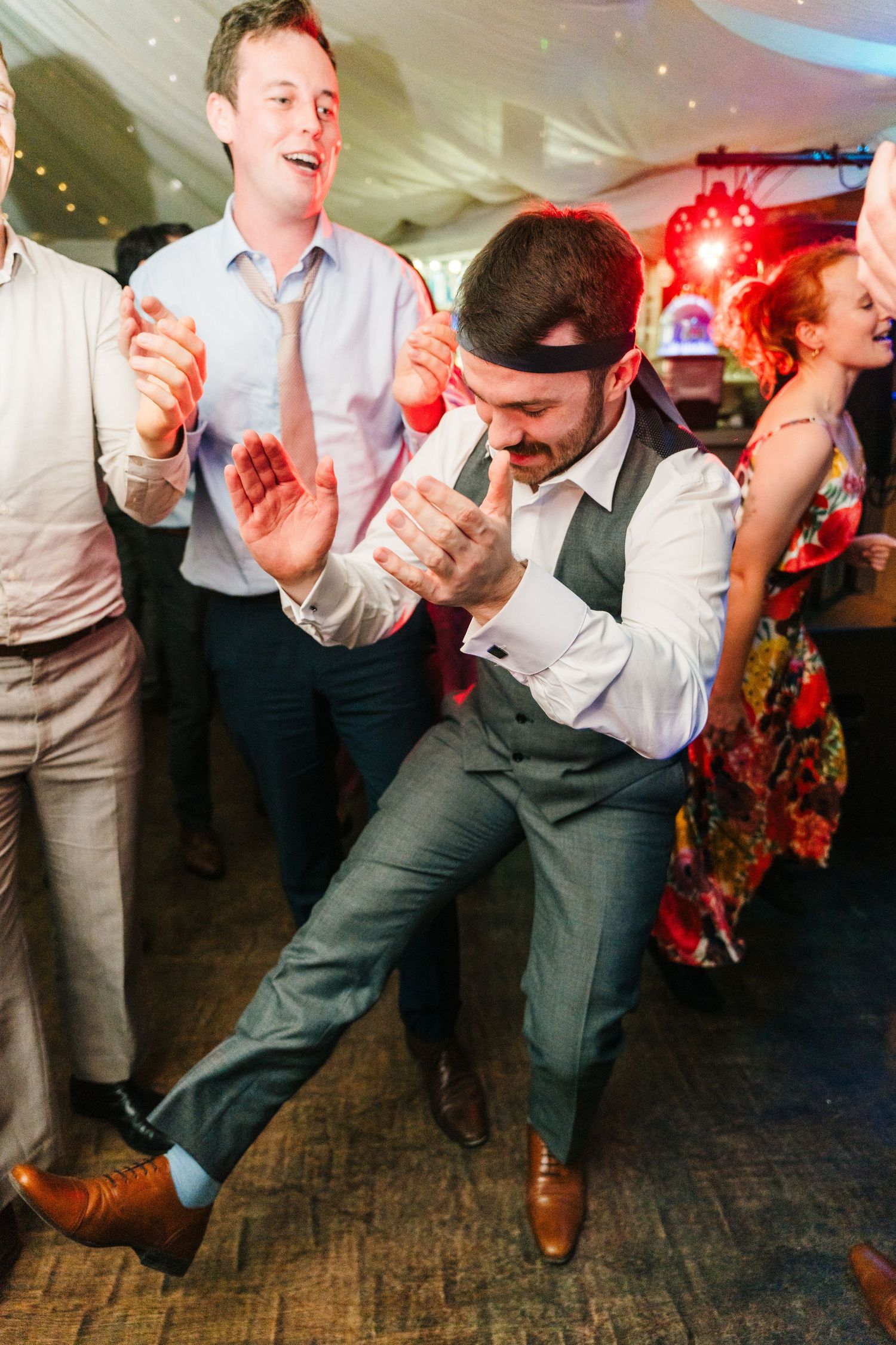 Millhouse slane wedding photographer dublin Wedding guests dance energetically at reception with colorful lighting and decorations.