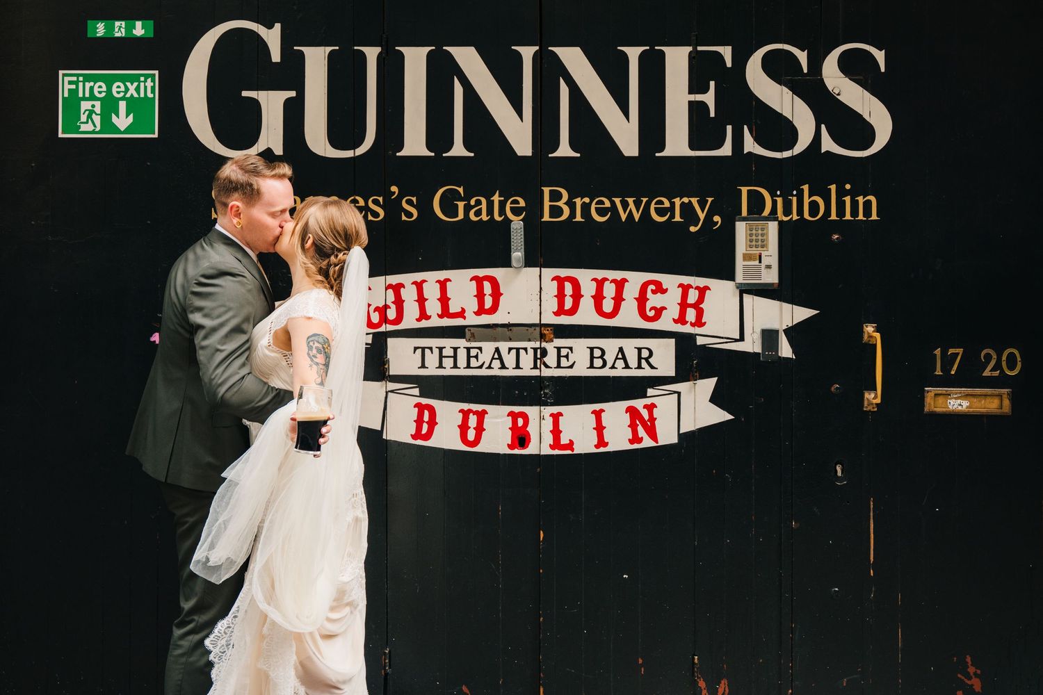 A romantic moment captured in front of the iconic Guinness brewery sign in Dublin. PHOTOGRAPHER Dublin Ireland Wedding