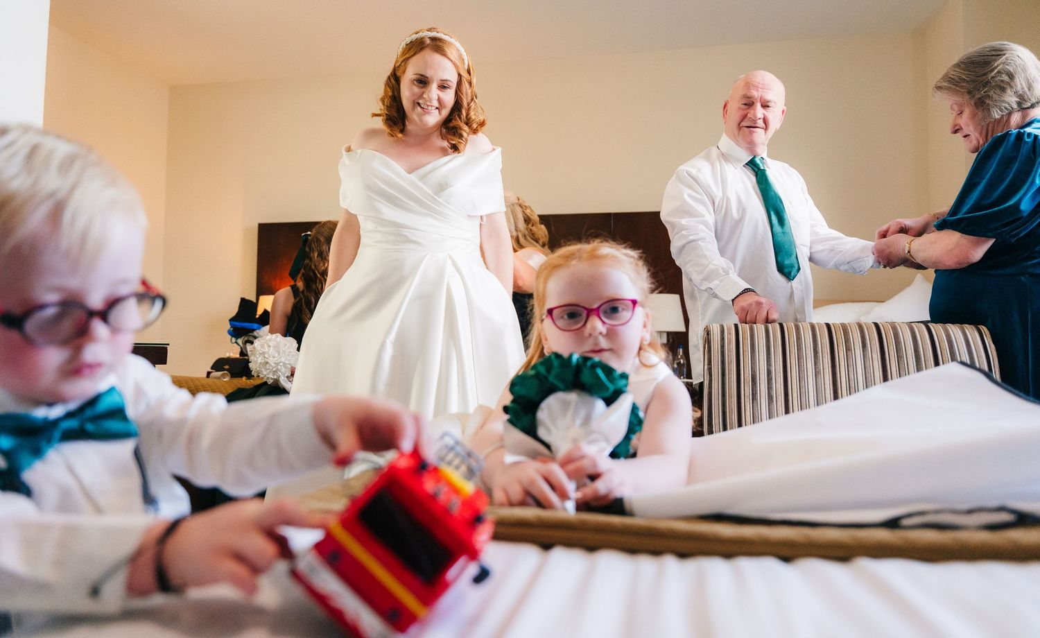 Wedding preparation scene with matching light blue bowties being adjusted on small attendants.  Wedding PHOTOGRAPHER Trim Castle