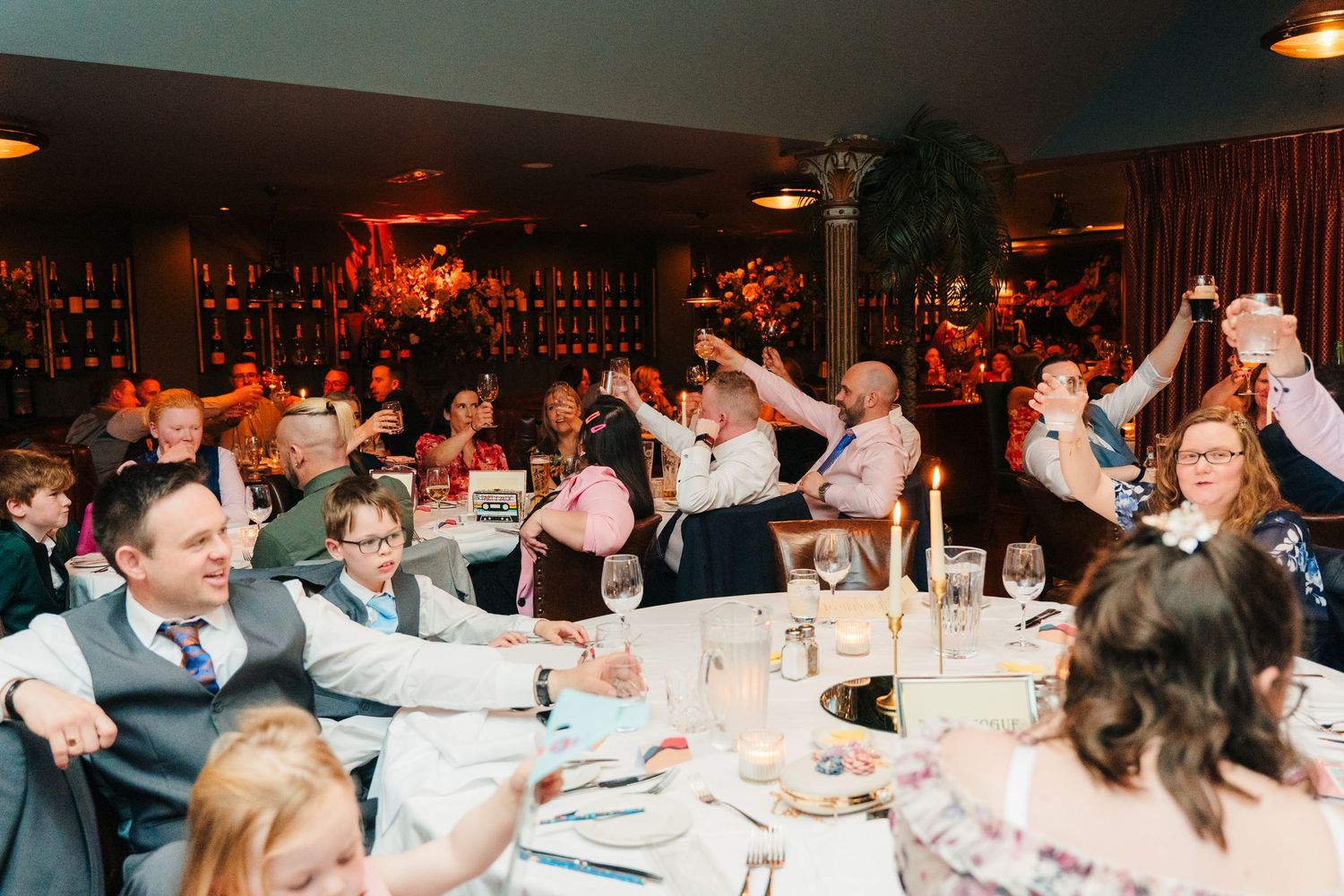 Wedding reception guests celebrating together in a banquet hall. Marco Pierre Dublin Wedding Photographer
