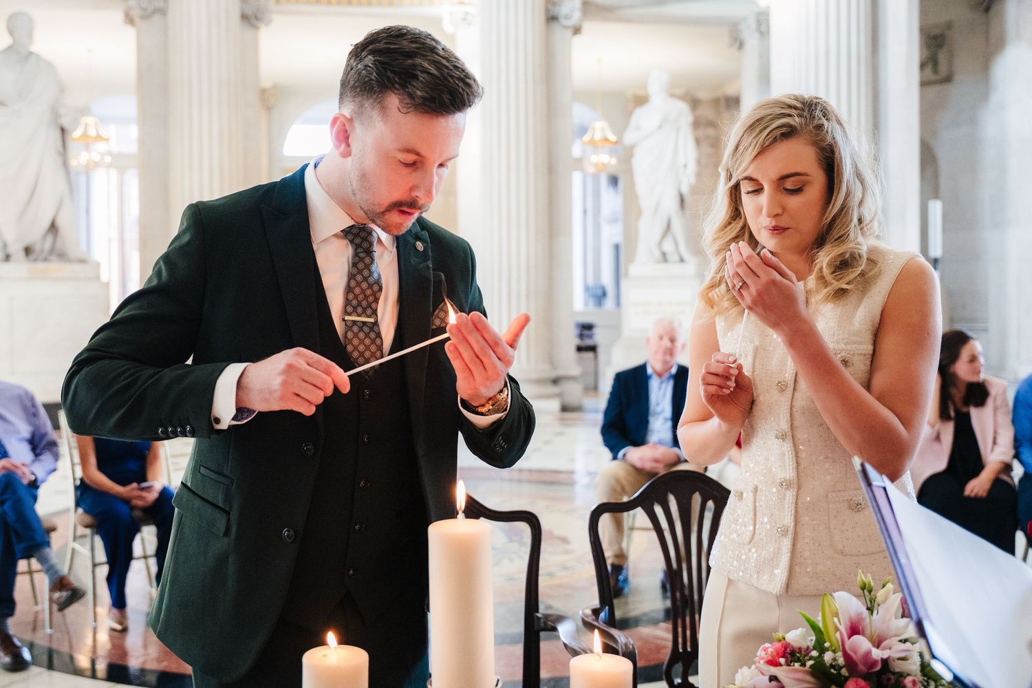 Elegant couple dining at formal reception with white columns and candlelight. City Hall Dublin wedding photogrAPher